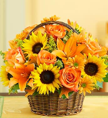 Orange roses and sunflowers in a wicker basket