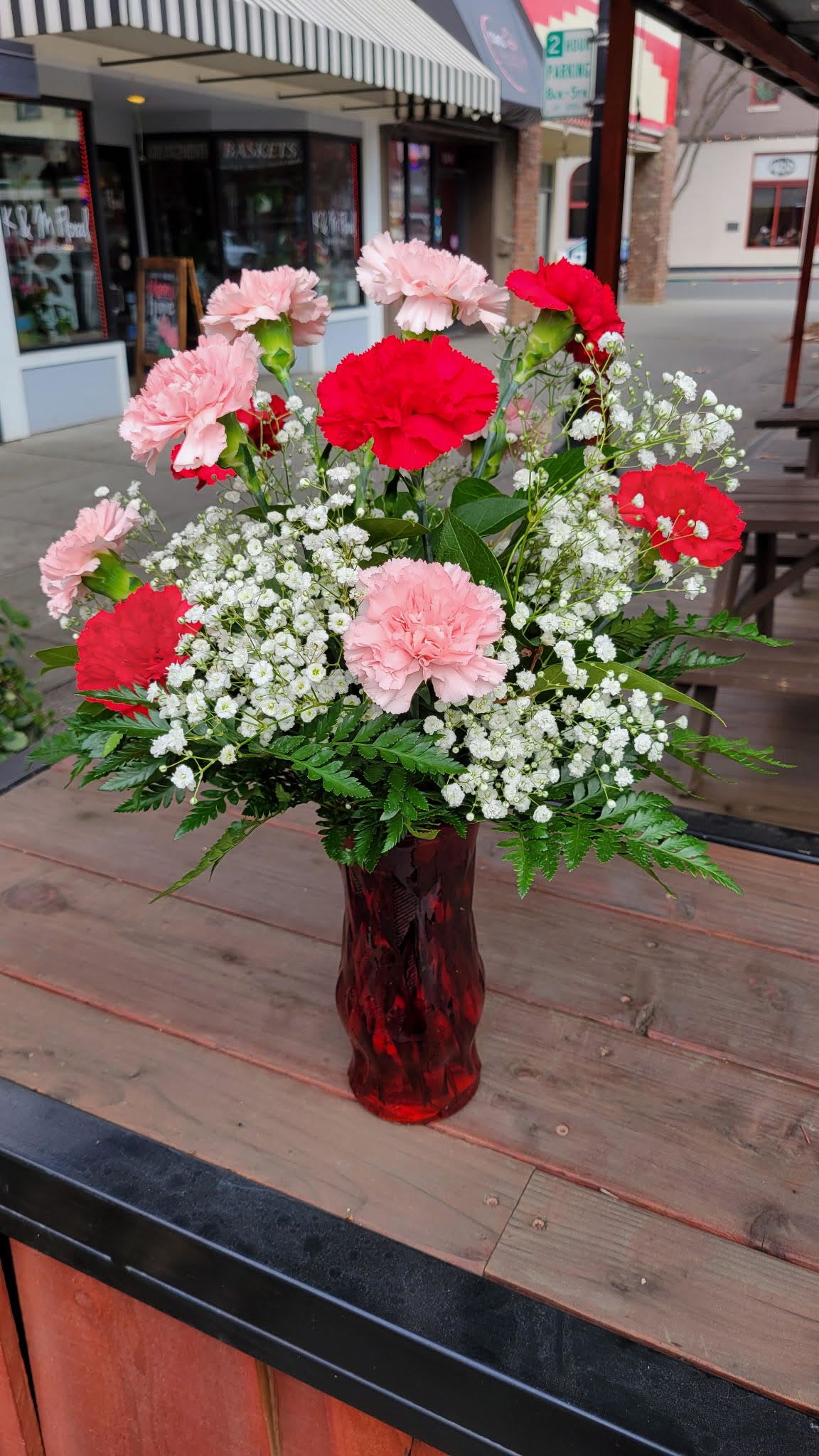 Pink and red carnations in a red glass vase