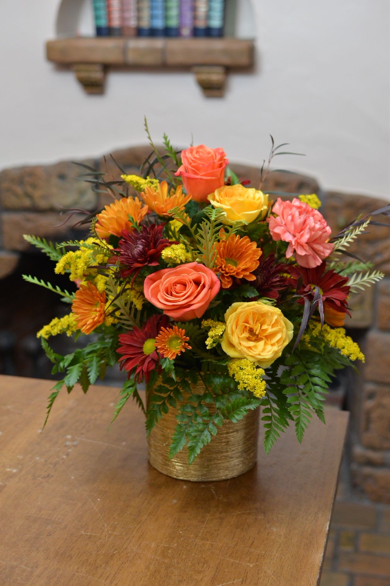 Mixed bouquet of roses and chrysanthemums in a gold vase
