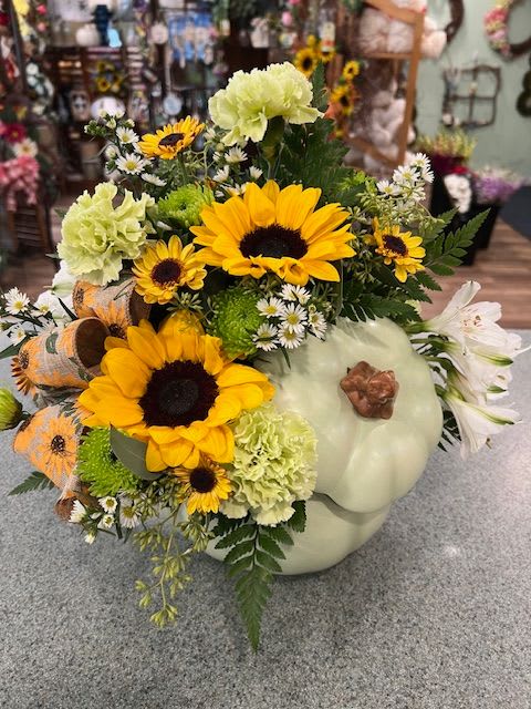 Sage Pumpkin (ASP) - Our beautiful sage colored ceramic pumkin with lid is filled with fall colored flowers. Such as green carnations. sunflowers, alstromeria and more. A beautiful gift.