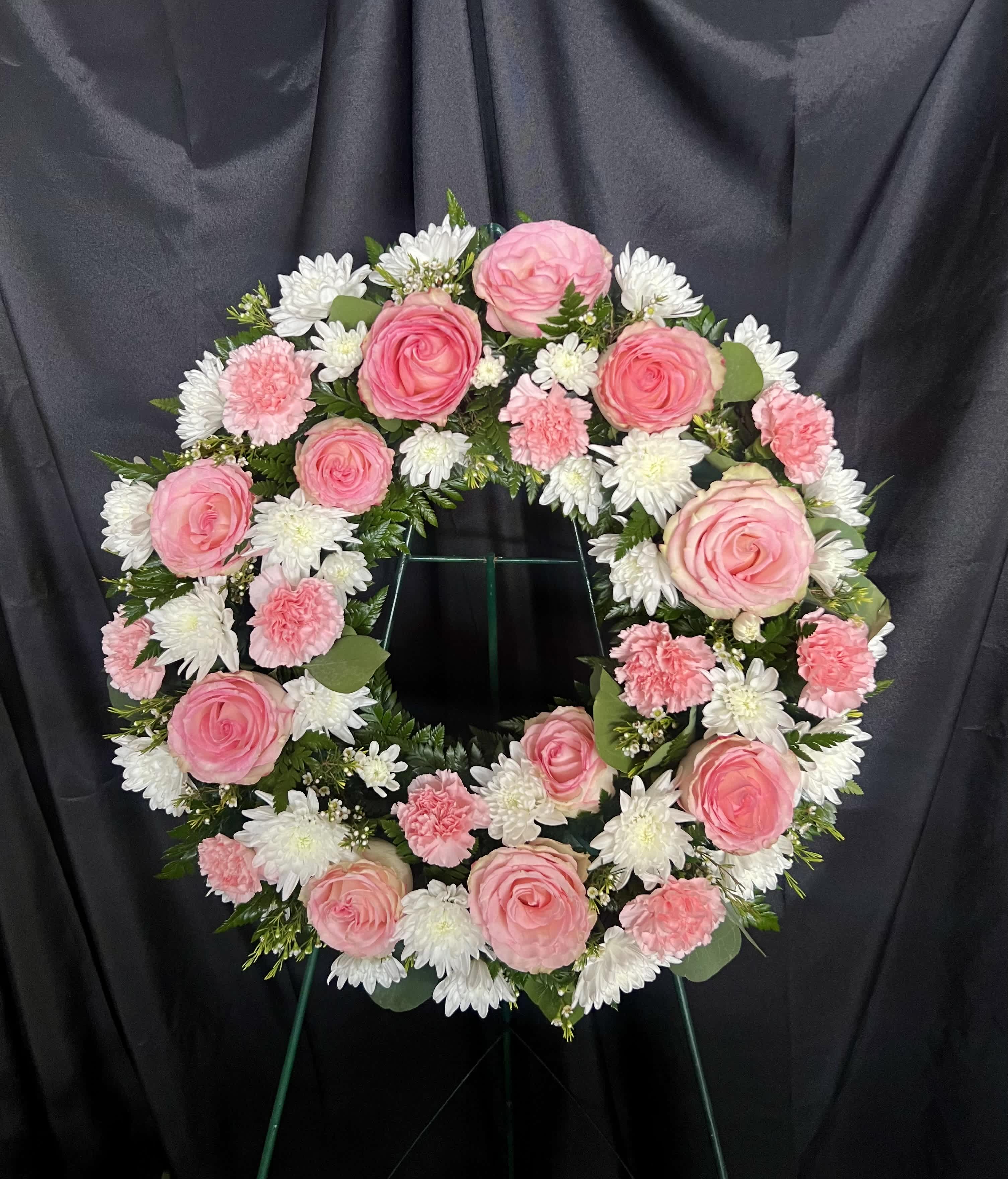Pink and white floral wreath on a stand