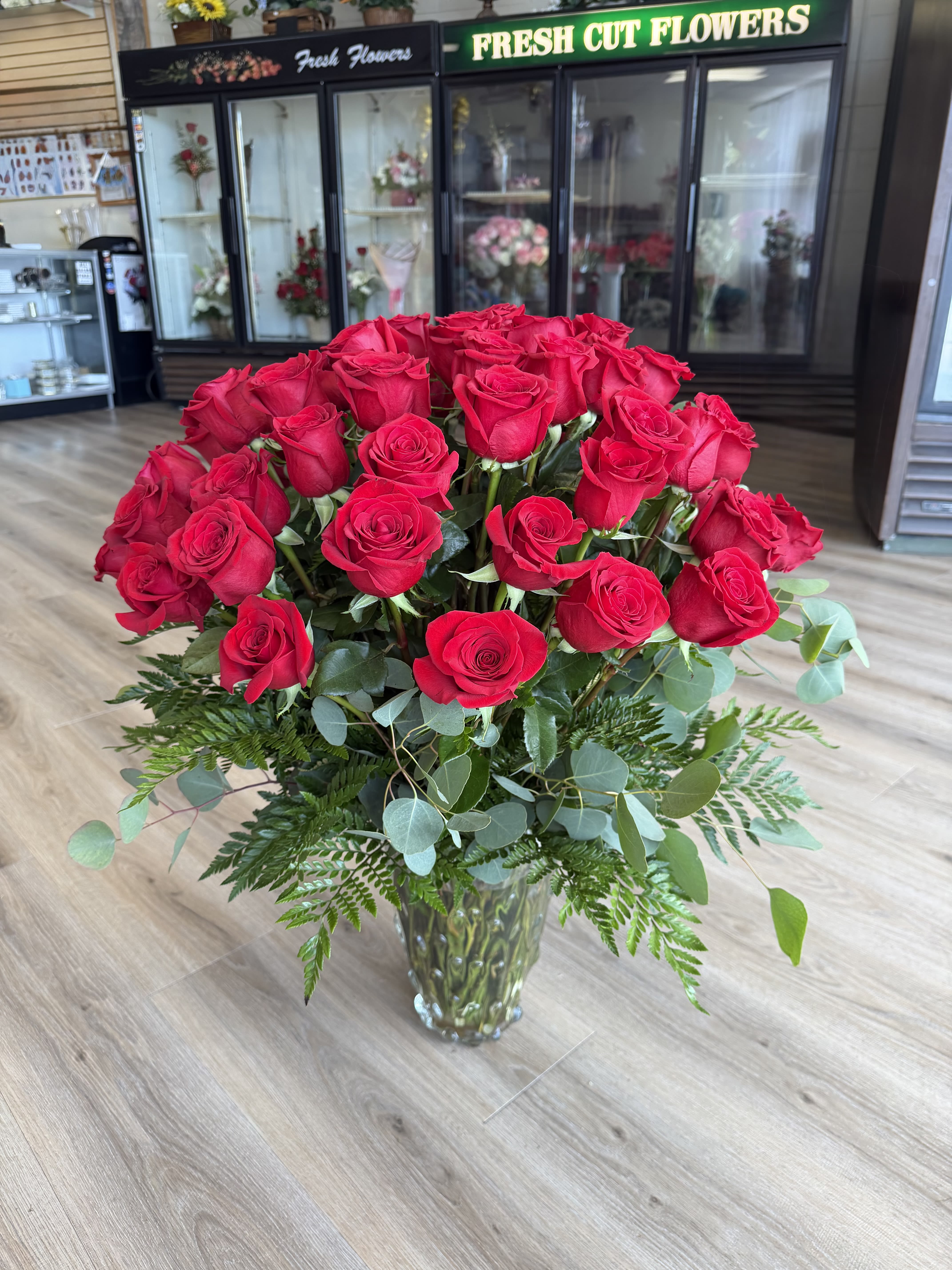 Grand Arrangement  - A lush 60ct dome of vivid red roses creates an immediate romantic impact - a classic red rose arrangement perfect for anniversaries, Valentine's Day, birthdays, or a heartfelt thank-you. The tightly packed, rounded silhouette reads as both formal and deeply personal, the kind of bouquet that makes the person you're thinking of feel truly celebrated and loved. 