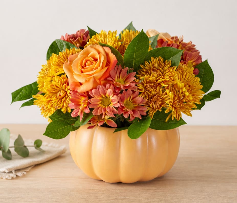 Orange rose and yellow chrysanthemum arrangement in a pumpkin-shaped container