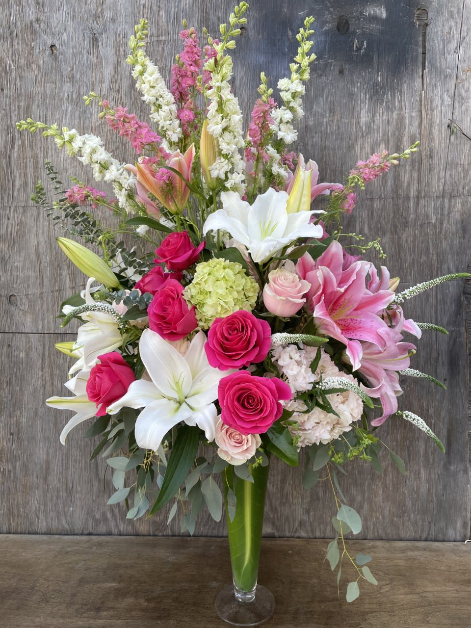 Tall bouquet of pink and white flowers in a glass vase