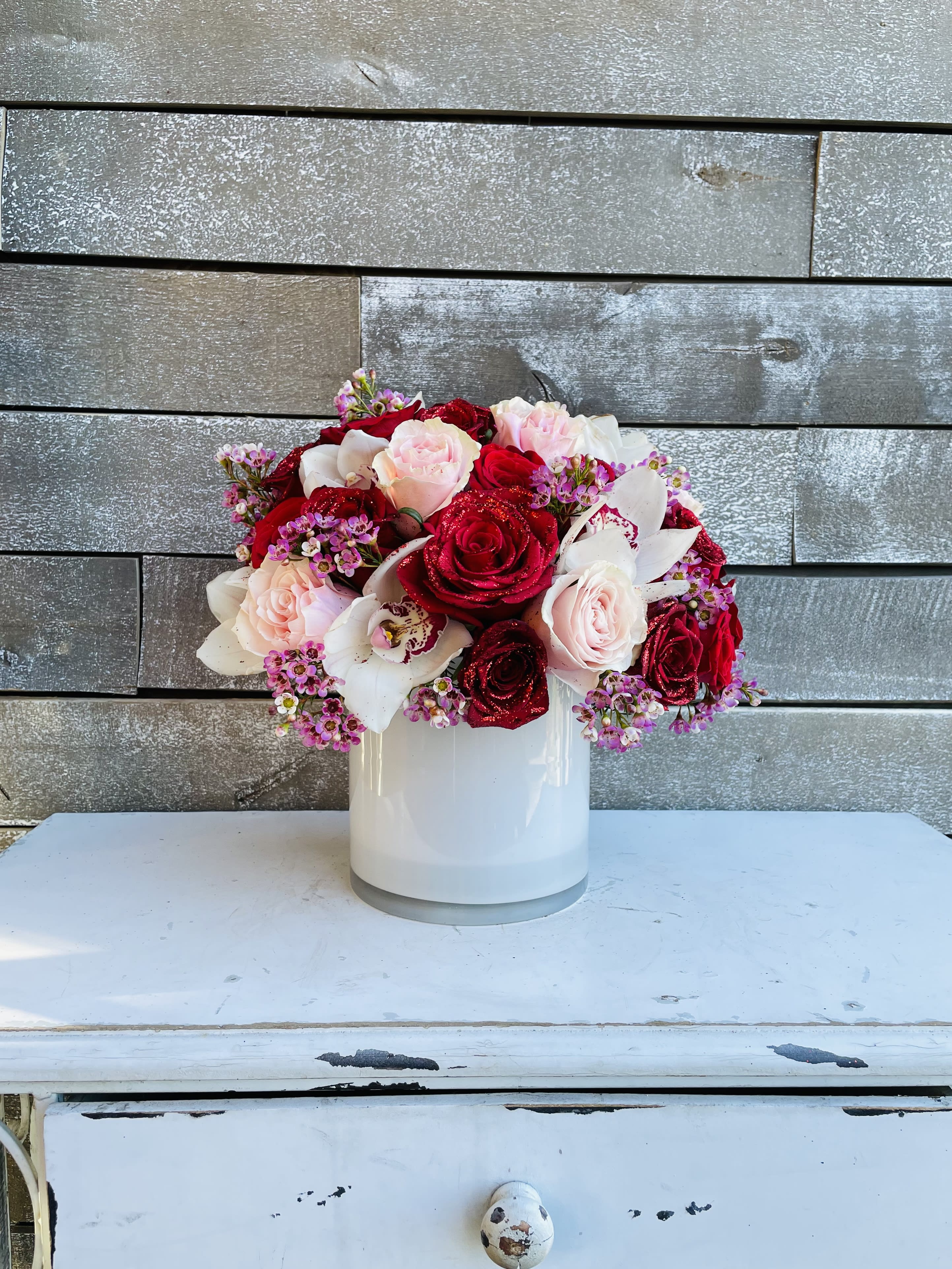 Bouquet of red and blush roses in a white vase