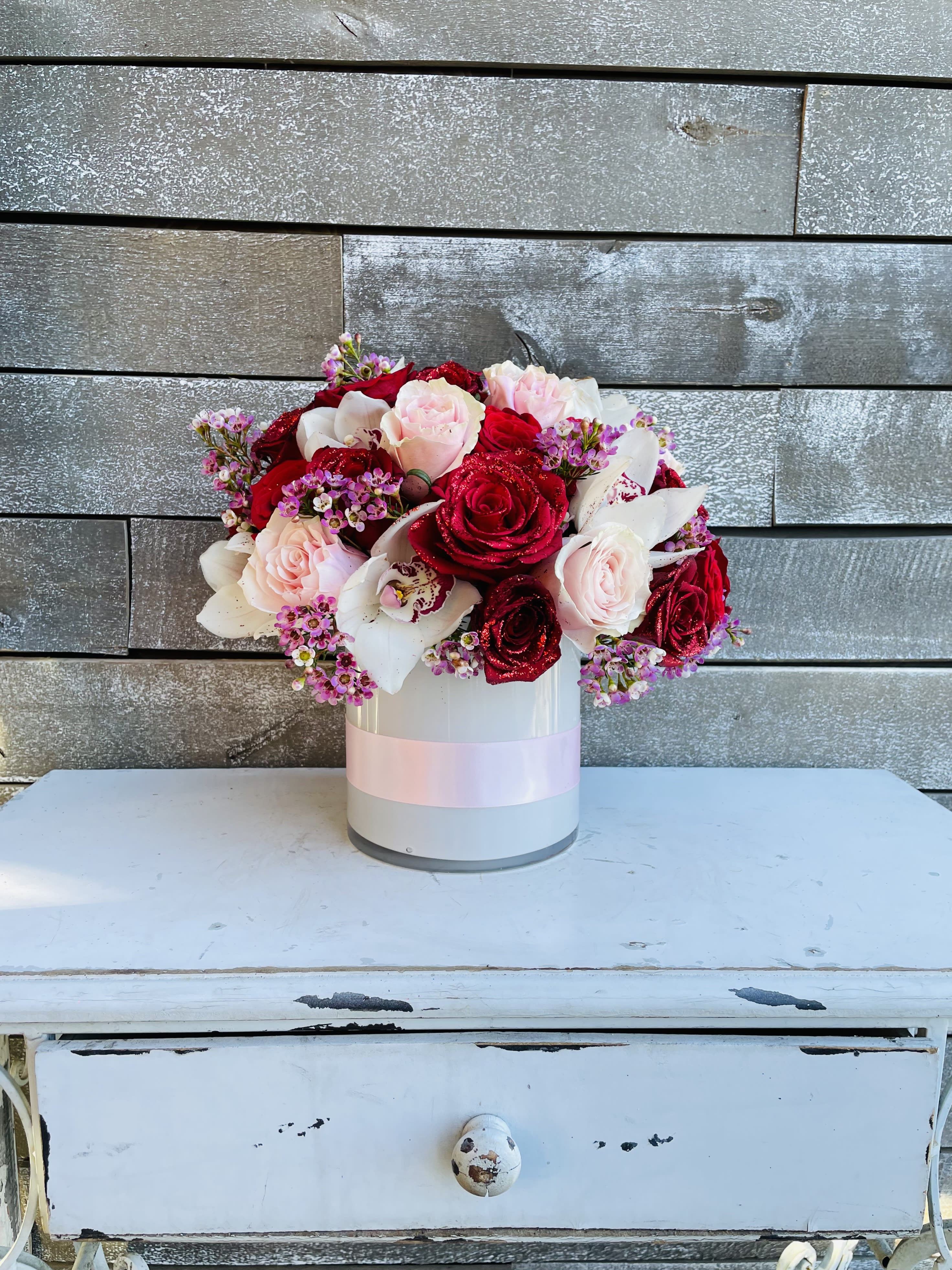 Bouquet of red and pale pink roses in a white hat box