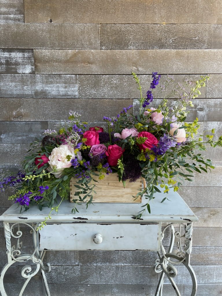 Mixed bouquet in a wooden box with pink, purple, and white flowers