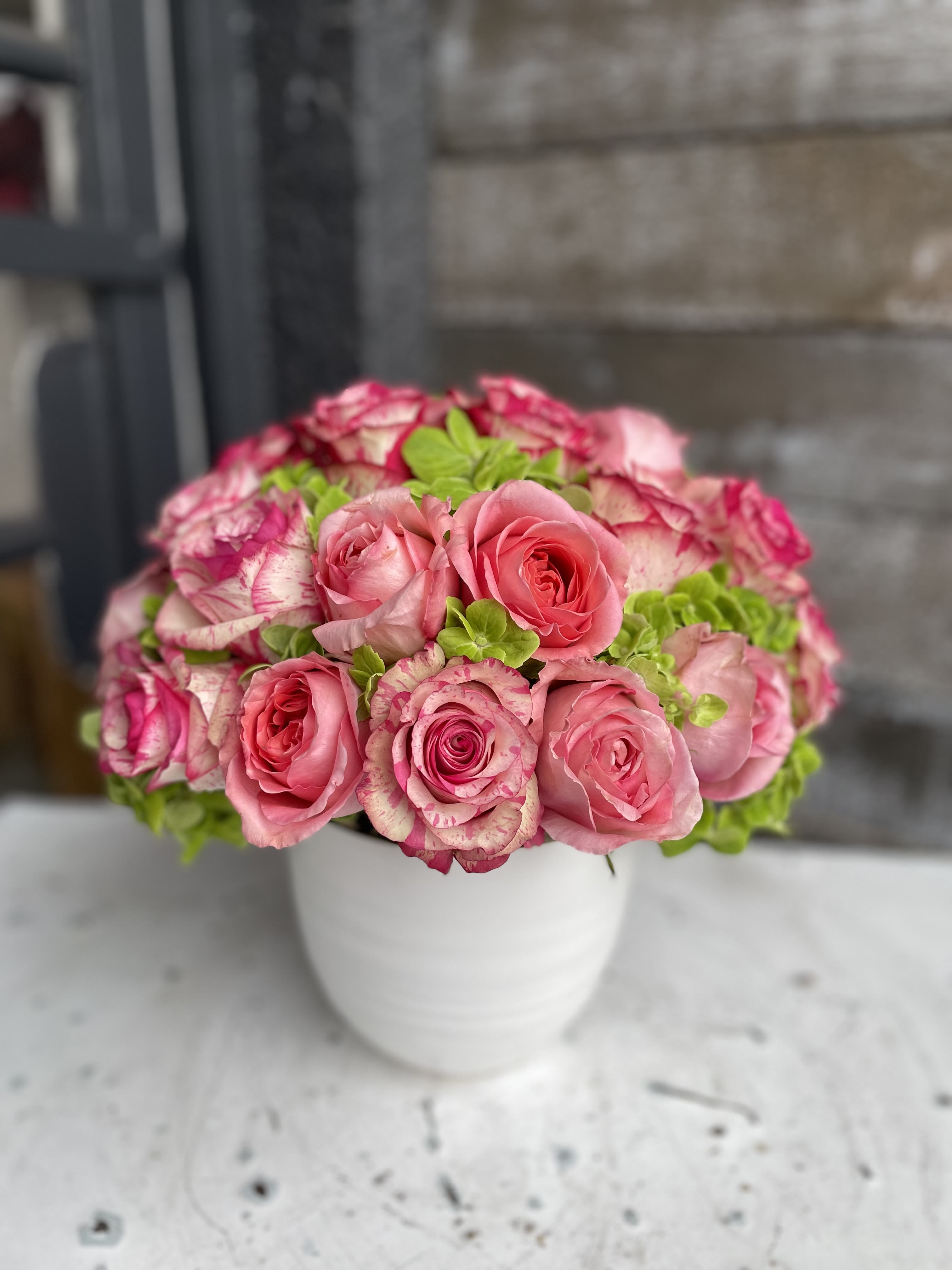 Pink roses arranged in a white vase