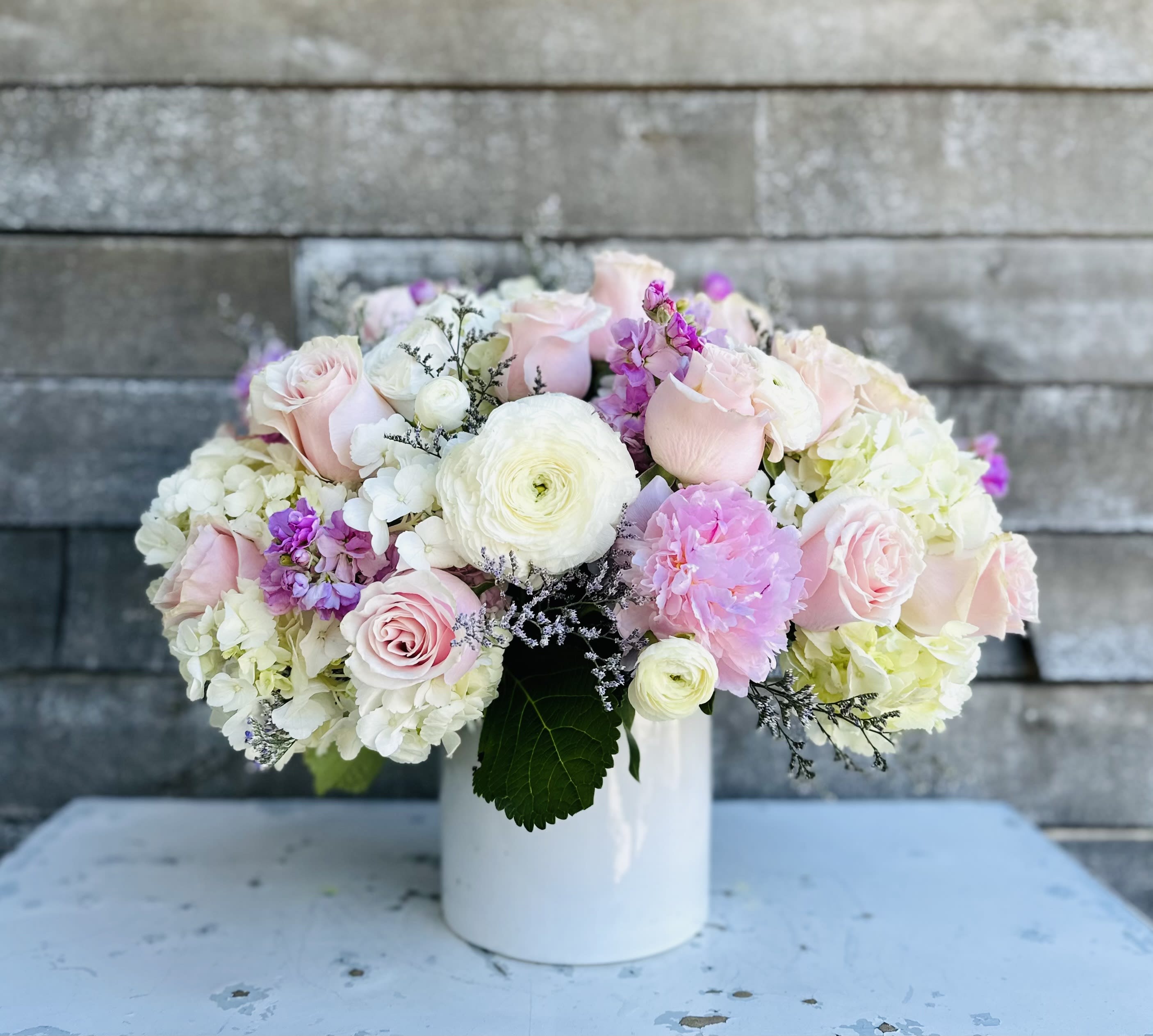 Pink and white flower arrangement in a white vase