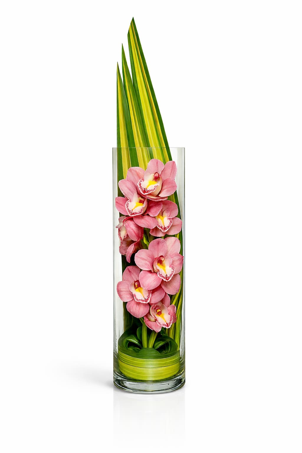 Pink orchids arranged in a tall glass vase with long green leaves