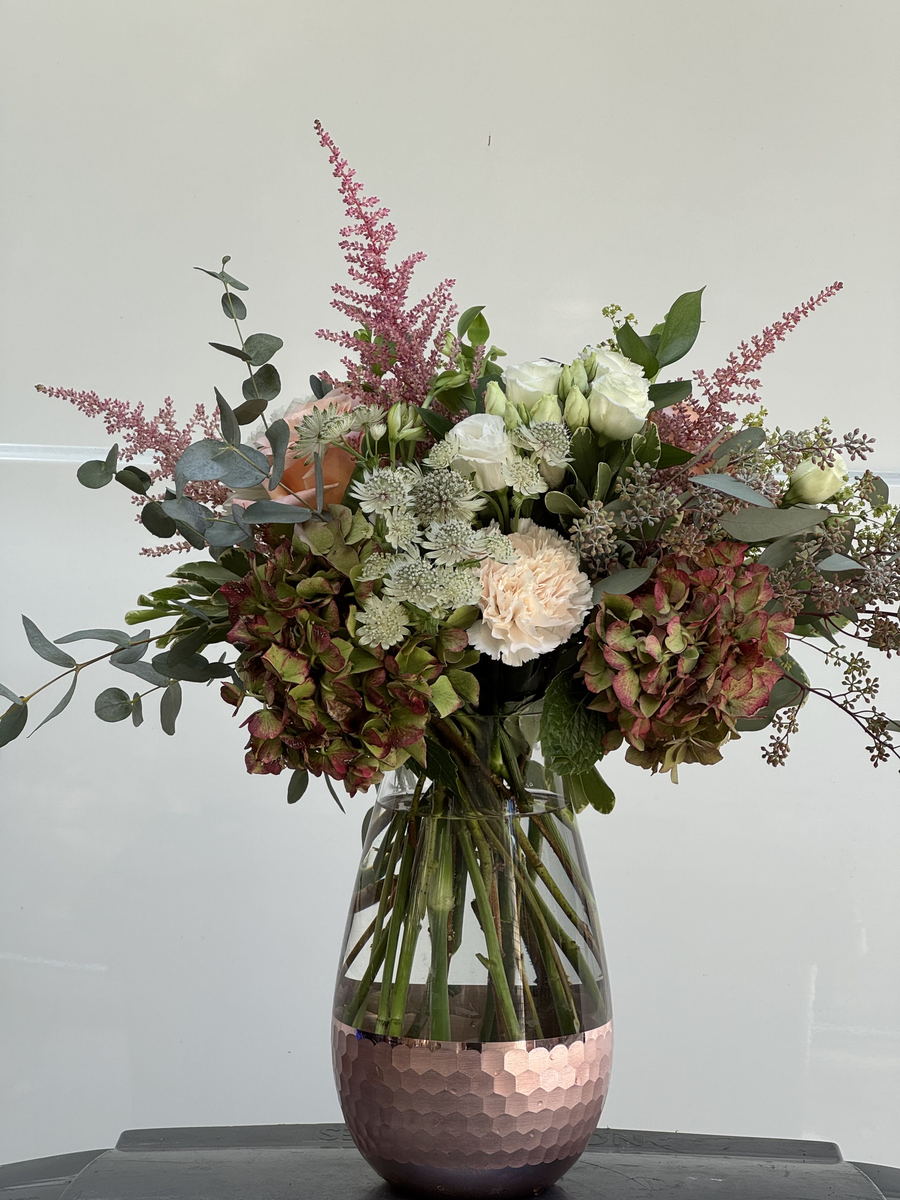 Mixed bouquet of white and blush flowers in a glass vase