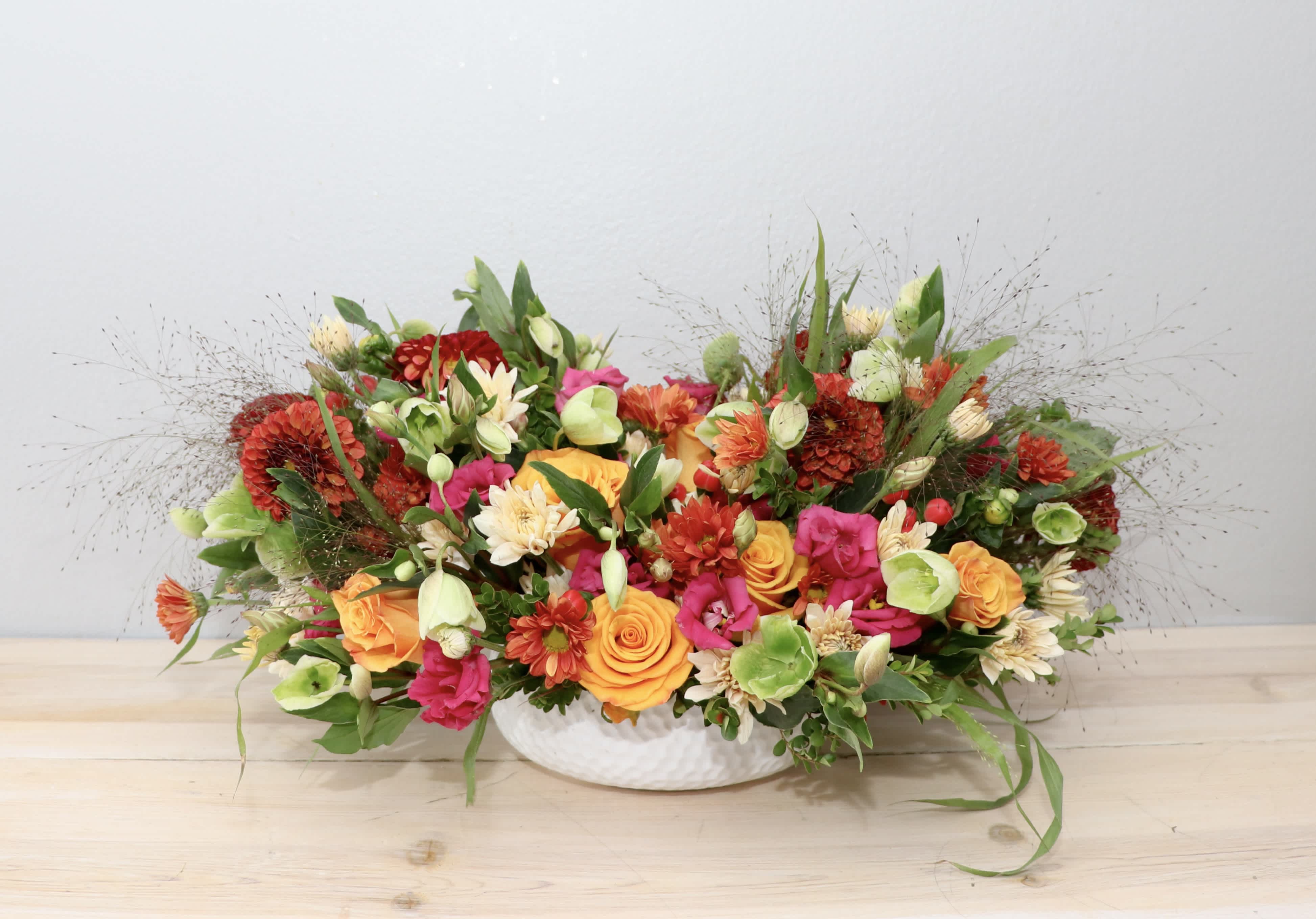 Colorful mixed flower arrangement in a white bowl vase