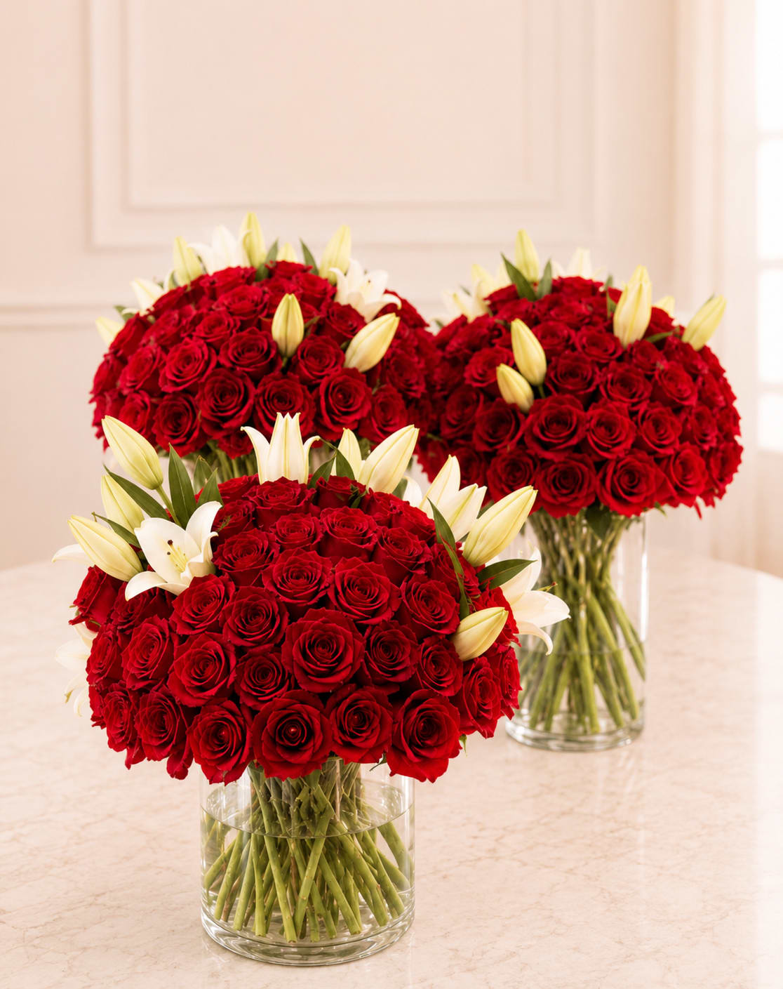 100 Red Roses with Lilies - Three dense, rounded bouquets of red roses paired with white lilies create a lush, romantic statement perfect for an anniversary or any love-and-romance moment. The strong red-and-white contrast reads both formal and heartfelt, the kind of gift that makes the person you're celebrating feel truly seen-whether it's for a birthday, Valentine's Day, Mother's Day, or simply a "just because" surprise.