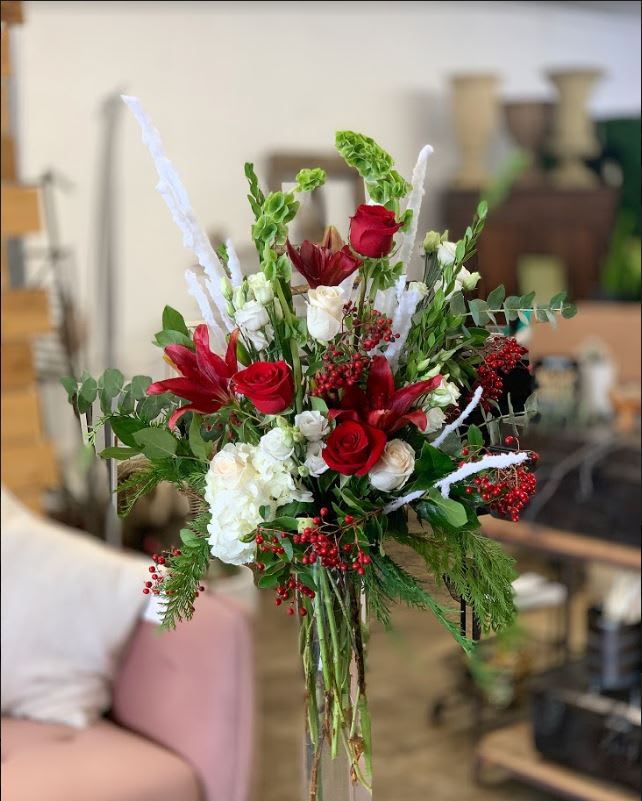 Christmas Roses Gallore - Holiday cheer for all to hear!! Send this beautiful mix of Christmas greens and textures, eloquently garnished with matching colors and florals to match the cheerful season!  pictured: [DELUXE]