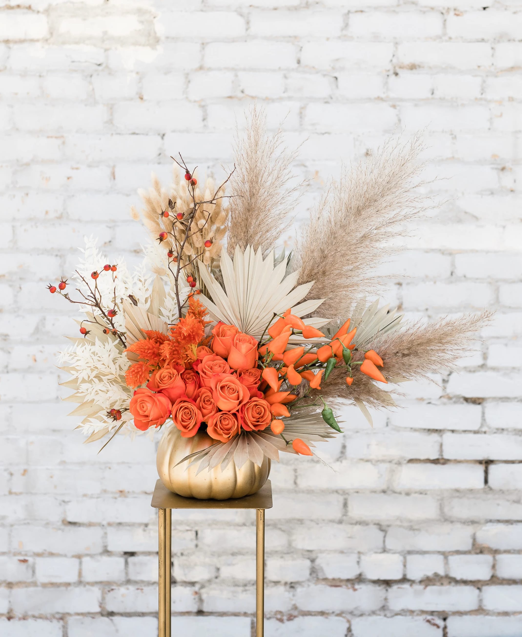 Jumping Jack Flash - Stunning Autumn mix of orange roses, seasonal blooms and textures for the season! Eloquently designed in a ceramic pumpkin, this arrangement will surely stun your friends and family.   Pictured [PREMIUM]