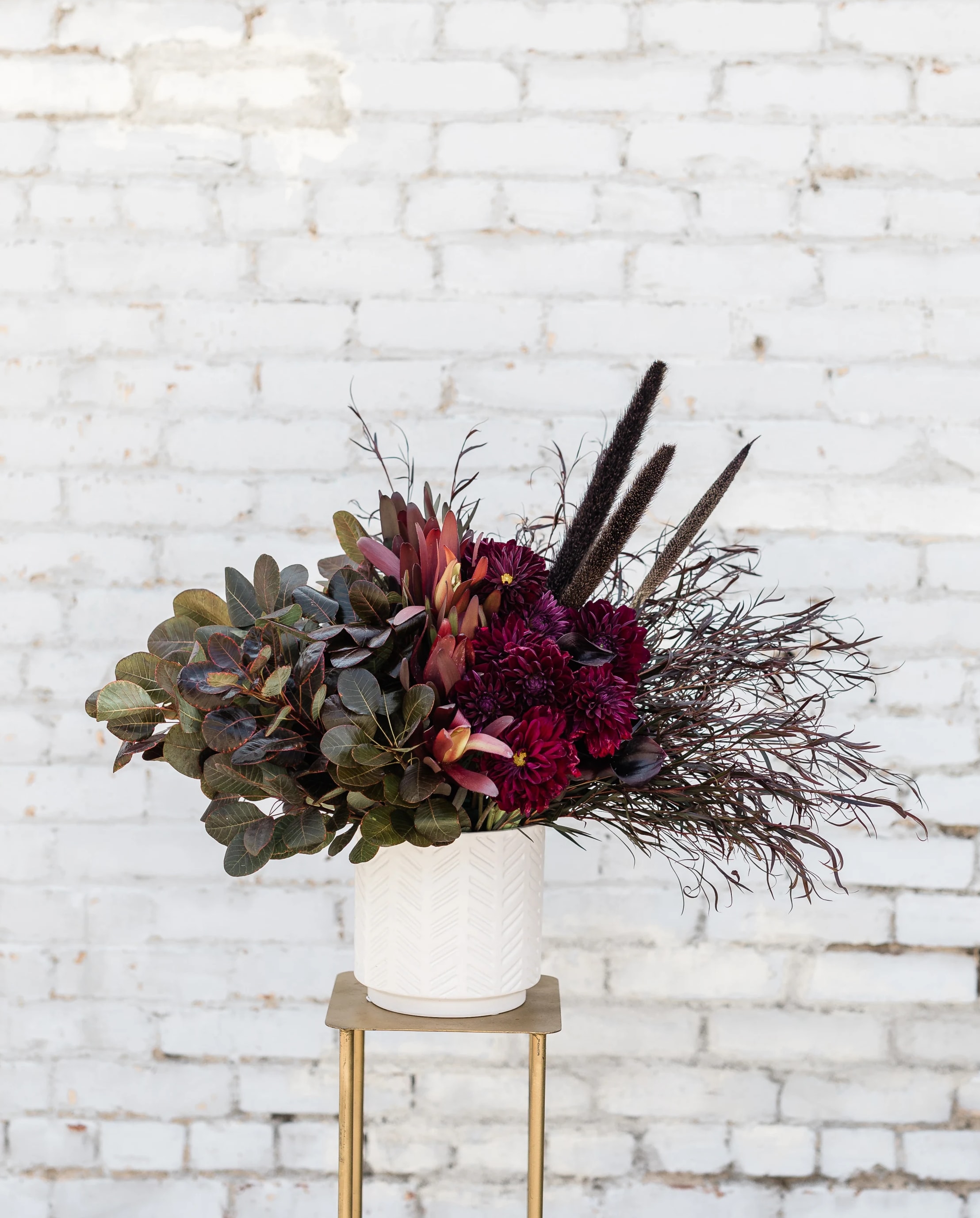 Paint it Black - This striking arrangement has moody tones of deep burgundy dahlias (when in season) partnered with jewel tones of merlot and maroon textures of the fall season.  Pictured [DELUXE]  *Some items in this arrangement are only available in certain seasons, substitutions will occur.*
