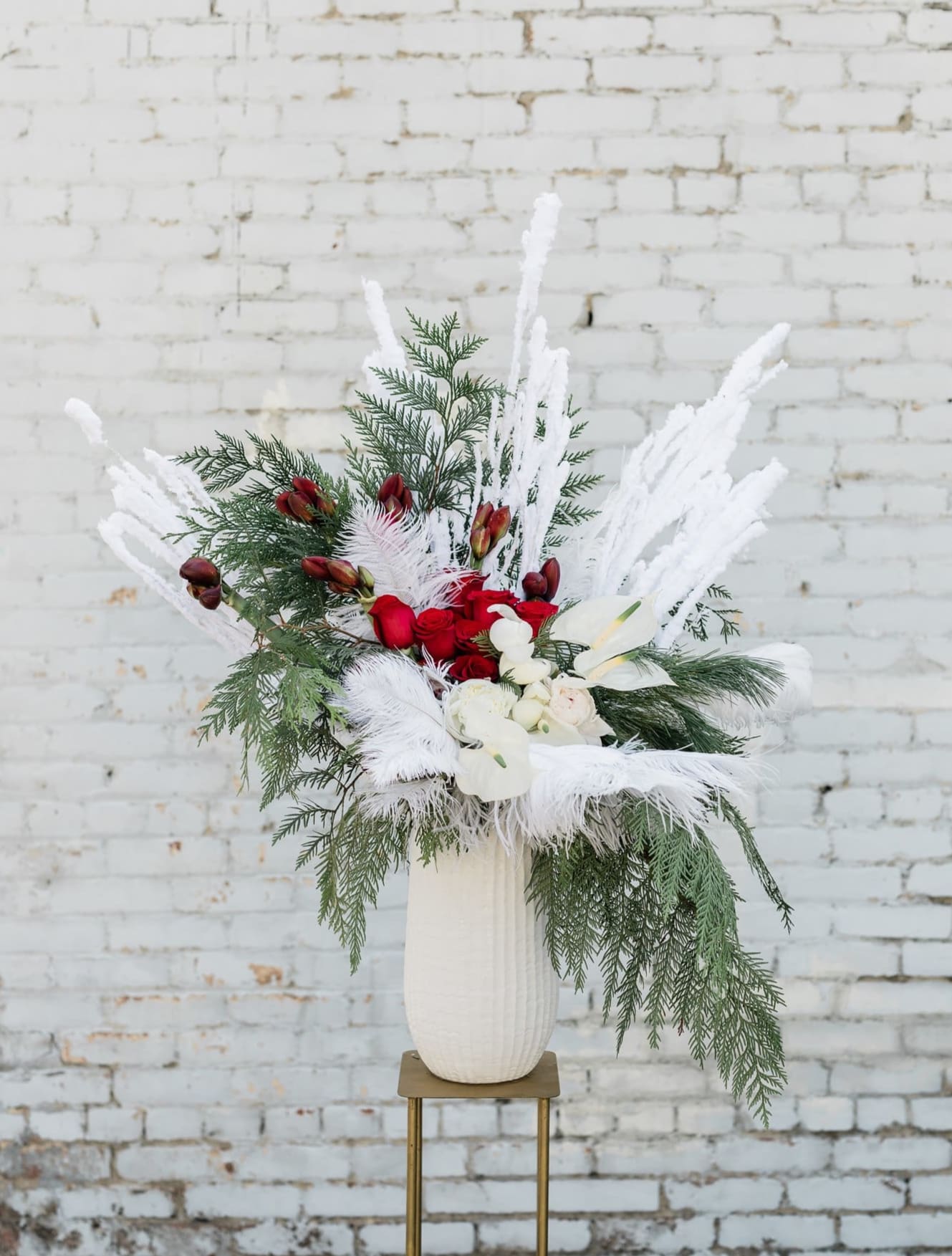 I Drink Wine - Part of this year's winter collection inspired by Adele's new album, 30, this grand arrangement is packed full of luscious red and white blooms, fragrant wintery twigs and textures, and soft white feathers, all designed in one of our hand-picked designer vases.  Pictured is [PREMIUM]