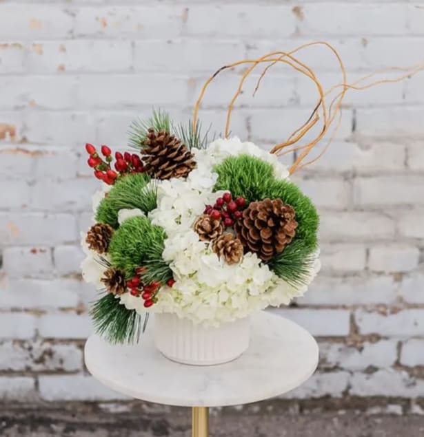 Jolly Holiday - Cozy on up and Drink in the Holiday Spirit with our new Winter Collection! Designed to capture the essence of the holidays and bring joy to all. Have a Jolly Holiday this season by bringing the joy of this arrangement home. Arranged with a stunning mix of white and green  blooms and winter textures, all eloquently designed in one of our hand-picked designer vases.  Pictured is [DELUXE]  *Some items in this arrangement must be special ordered, please allow 1-2 weeks notice to allow time for arrival of special items, otherwise, substitutions will occur.*