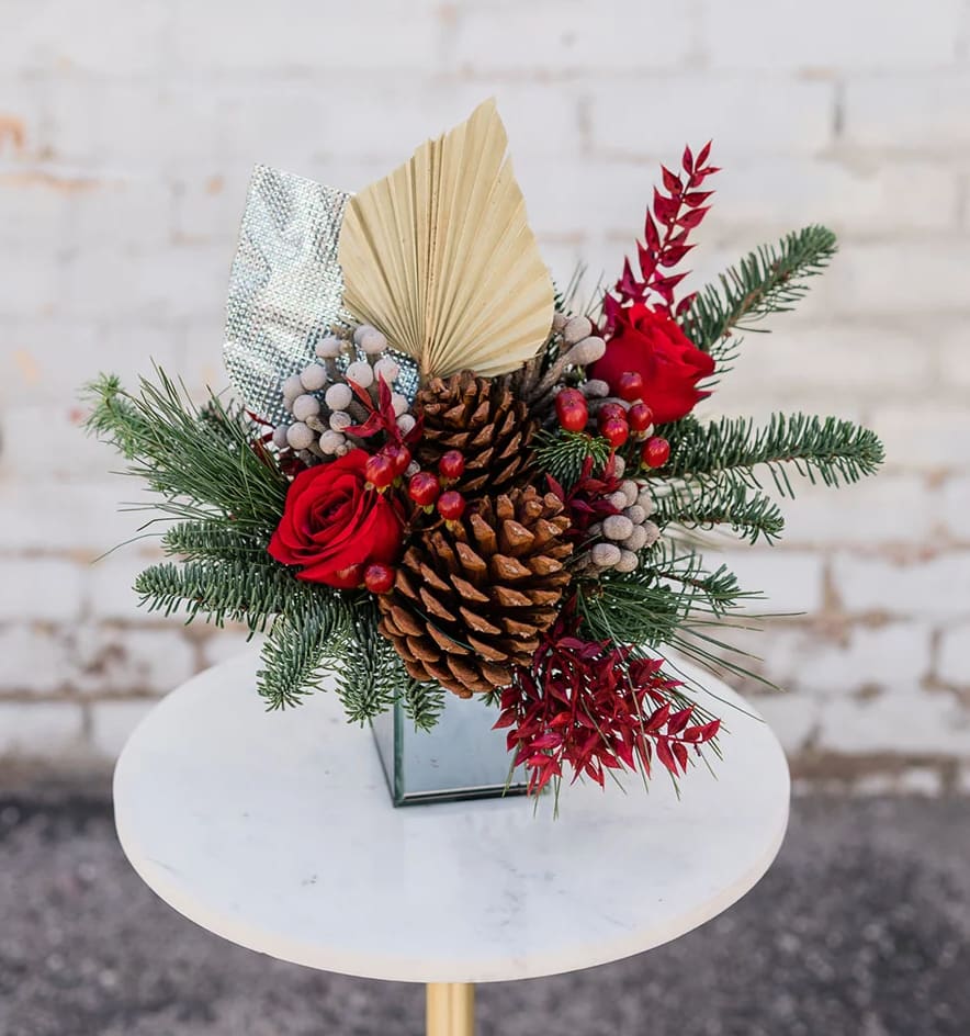 Misteltoe Kisses - Cozy on up and Drink in the Holiday Spirit with our new Winter Collection! Designed to capture the essence of the holidays and bring joy to all. Mistletoe Kisses will bring a fun pop to any home. Arranged with a stunning mix of red blooms, complimented by winter greens and textures all eloquently designed in one of our hand-picked designer vases.  Only ONE size available  *Some items in this arrangement must be special ordered, please allow 1-2 weeks notice to allow time for arrival of special items, otherwise, substitutions will occur.*