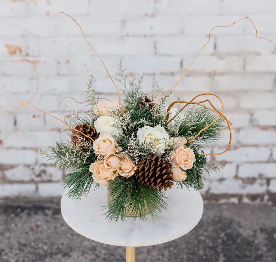 Underneath the Tree - Cozy on up and Drink in the Holiday Spirit with our new Winter Collection! Designed to capture the essence of the holidays and bring joy to all. Anyone would be excited to see this Underneath The Tree. Arranged with a stunning mix of neutral premium blooms and textures, accompanied by winter greens and textures all elegantly designed in one of our hand-picked designer vases.  Pictured is [STANDARD]  *Some items in this arrangement must be special ordered, please allow 1-2 weeks notice to allow time for arrival of special items, otherwise, substitutions will occur.*