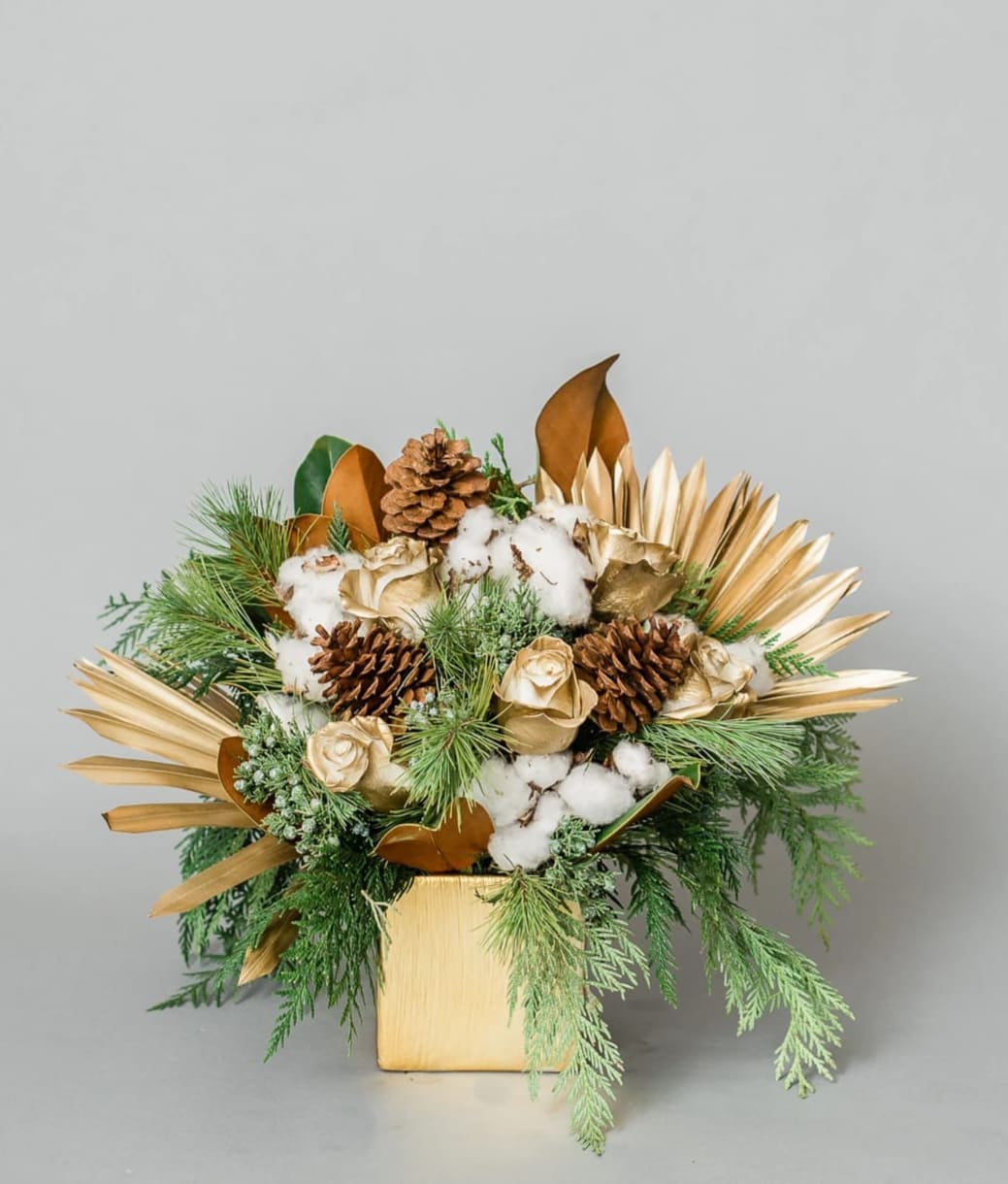 Yuletide Memory - Get in the Holly Jolly Spirit with our dreamy Holiday Collection! Inspired by the warmth and memories of holidays past, Yuletide Memory comes arranged with white and gold premium blooms and textures, accented with holiday greens, all elegantly arranged in one of our hand-picked designer vases.  Pictured [DELUXE]  *Some items in this arrangement must be special ordered, please allow 1-2 weeks notice to allow time for arrival of special items, otherwise, substitutions will occur.*