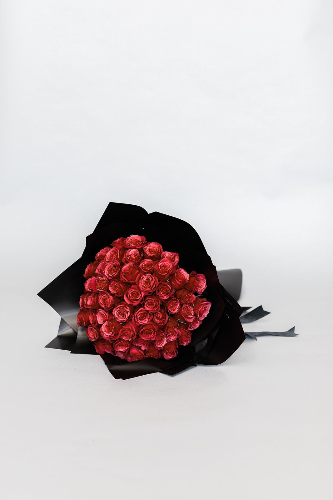Bouquet of red roses wrapped in black paper