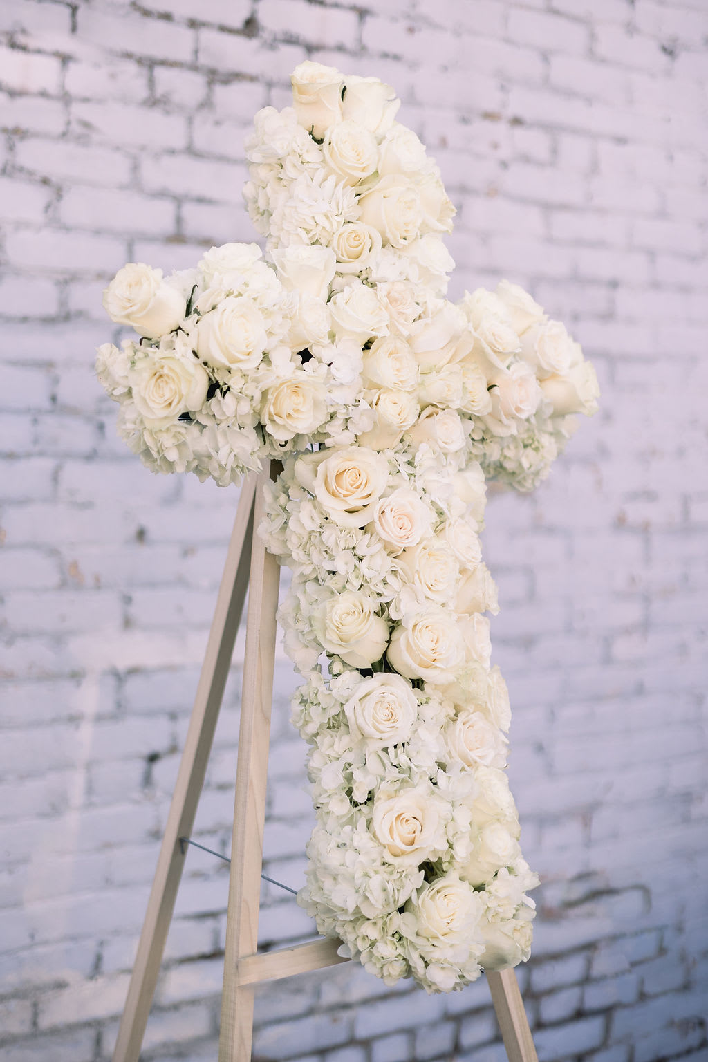 White floral cross on a wooden easel