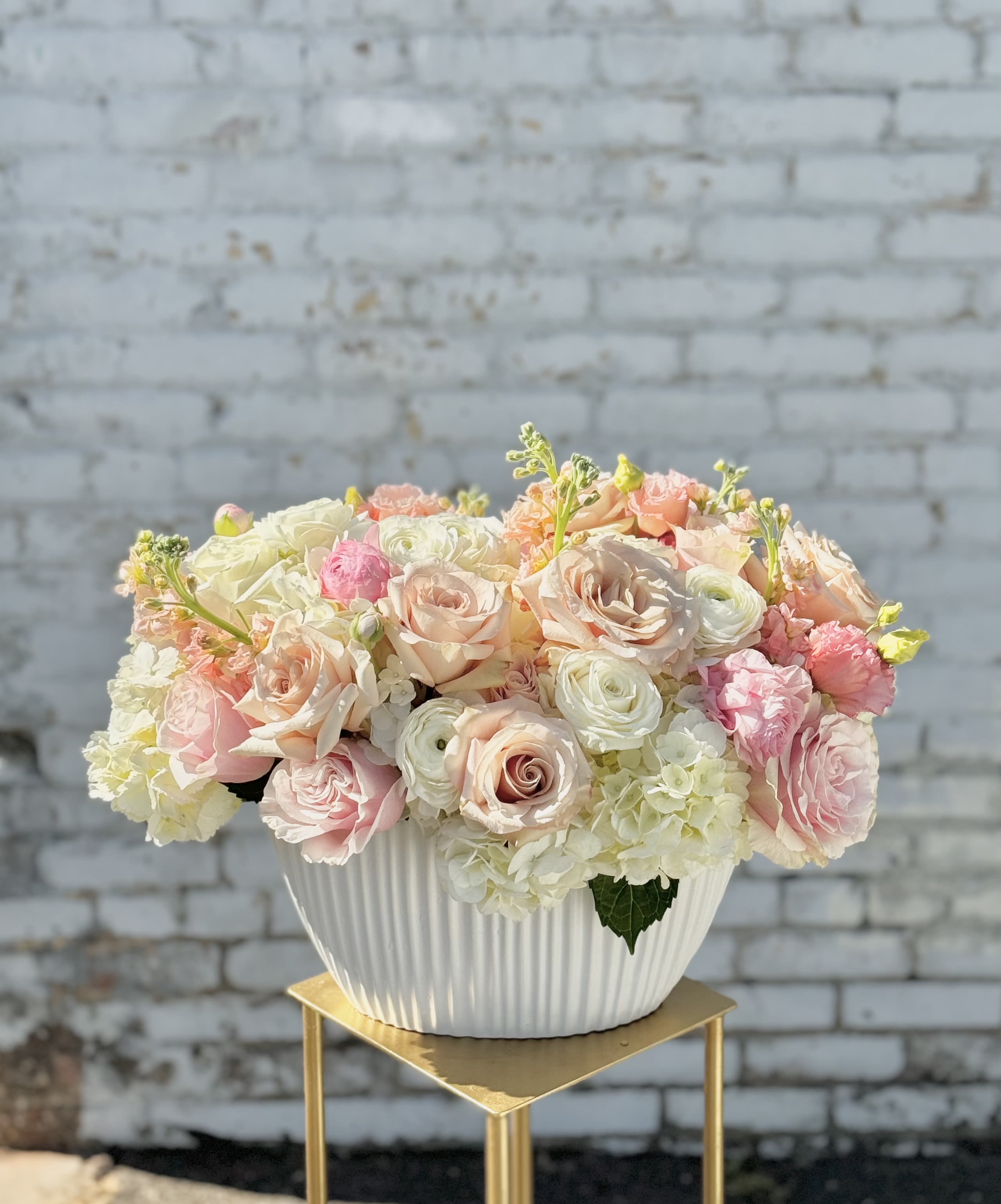 Pastel rose and hydrangea arrangement in a white ribbed bowl