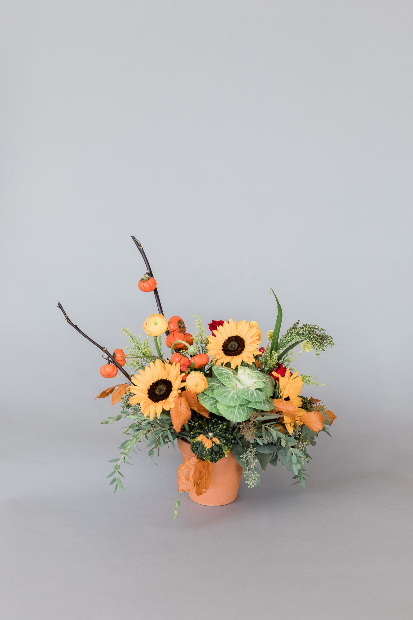 The Sweetest Sunrise - Beautiful red and orange roses, a sweet little pumpkin (while they are in season), coffee bean, falling leaves, and gorgeous greenery make for the sweetest colored sunrise, paired of course, in a terracotta pot.  (Photo Credit: Brian LaBrada)