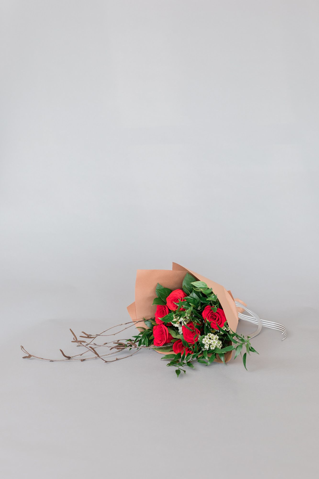 Bouquet of red roses wrapped in tan paper