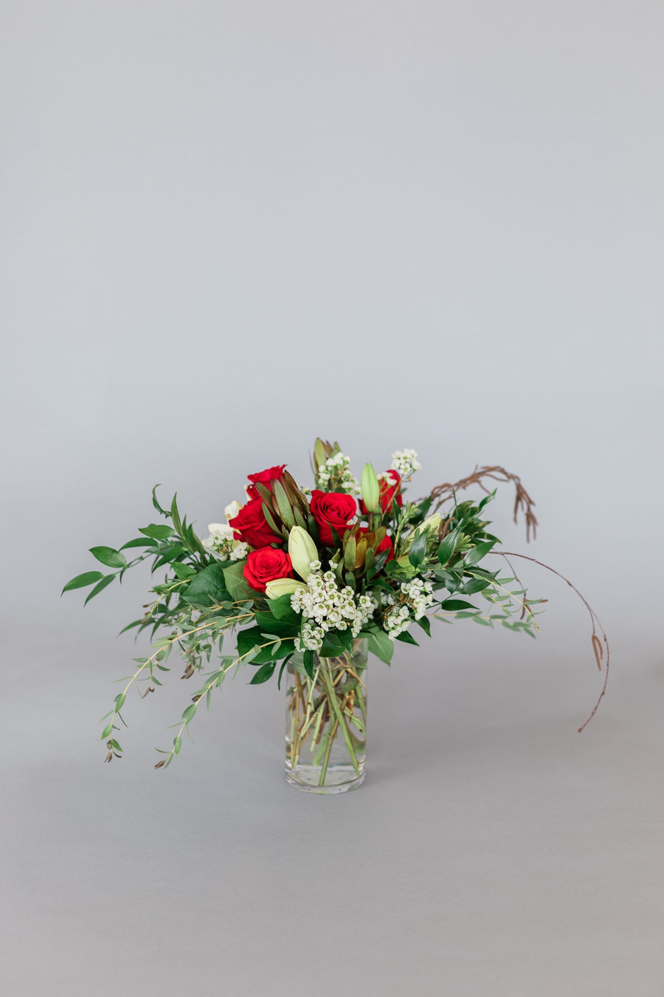 Red roses and white lilies in a clear glass vase