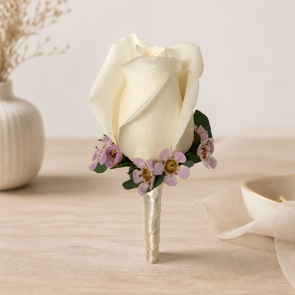 White rose boutonniere with small lavender flowers
