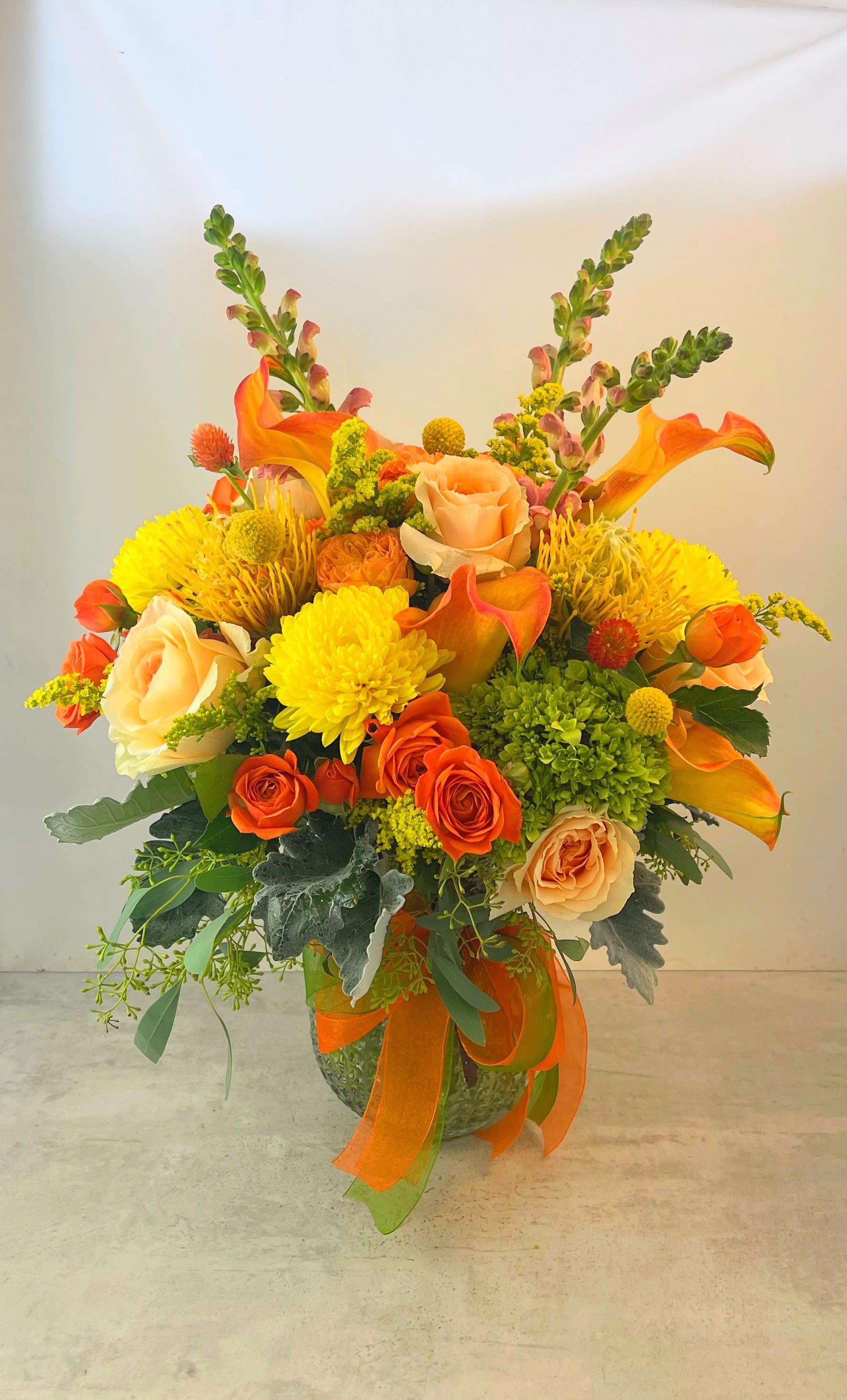 Mums &amp; Roses - Whats a fall bouquet without Mums!! So we've mixed bright seasonal chrysanthemums with autumnal colored roses and added  hydrangea dusty miller eucalyptus plus other seasonl blossoms. The Mums &amp; Roses bouquet is made the more traditional style.