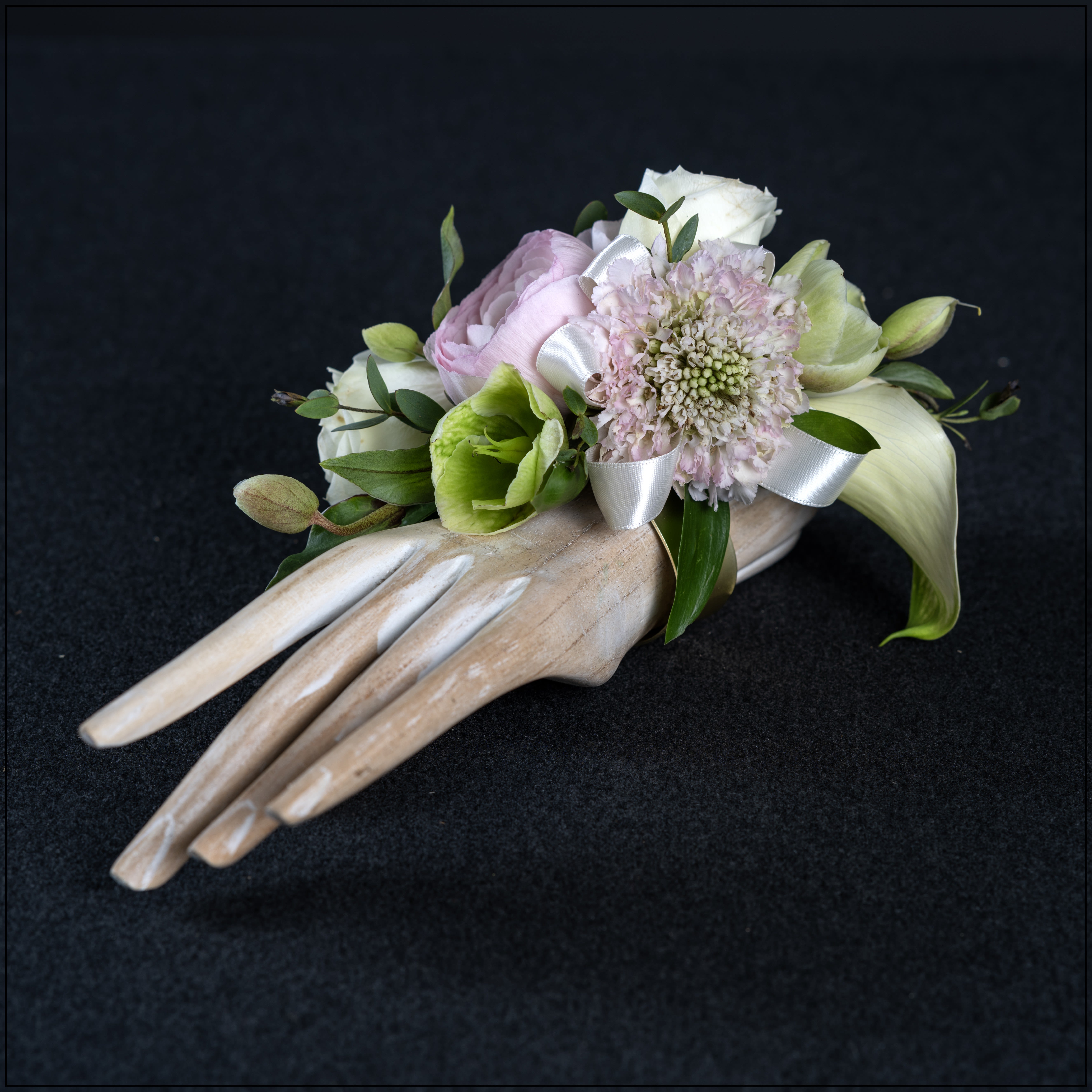Amanda corsage - Gorgeous wrist corsage featuring miniature calla lilies, spray roses, ranculus, scabiosa, and Helleborus.