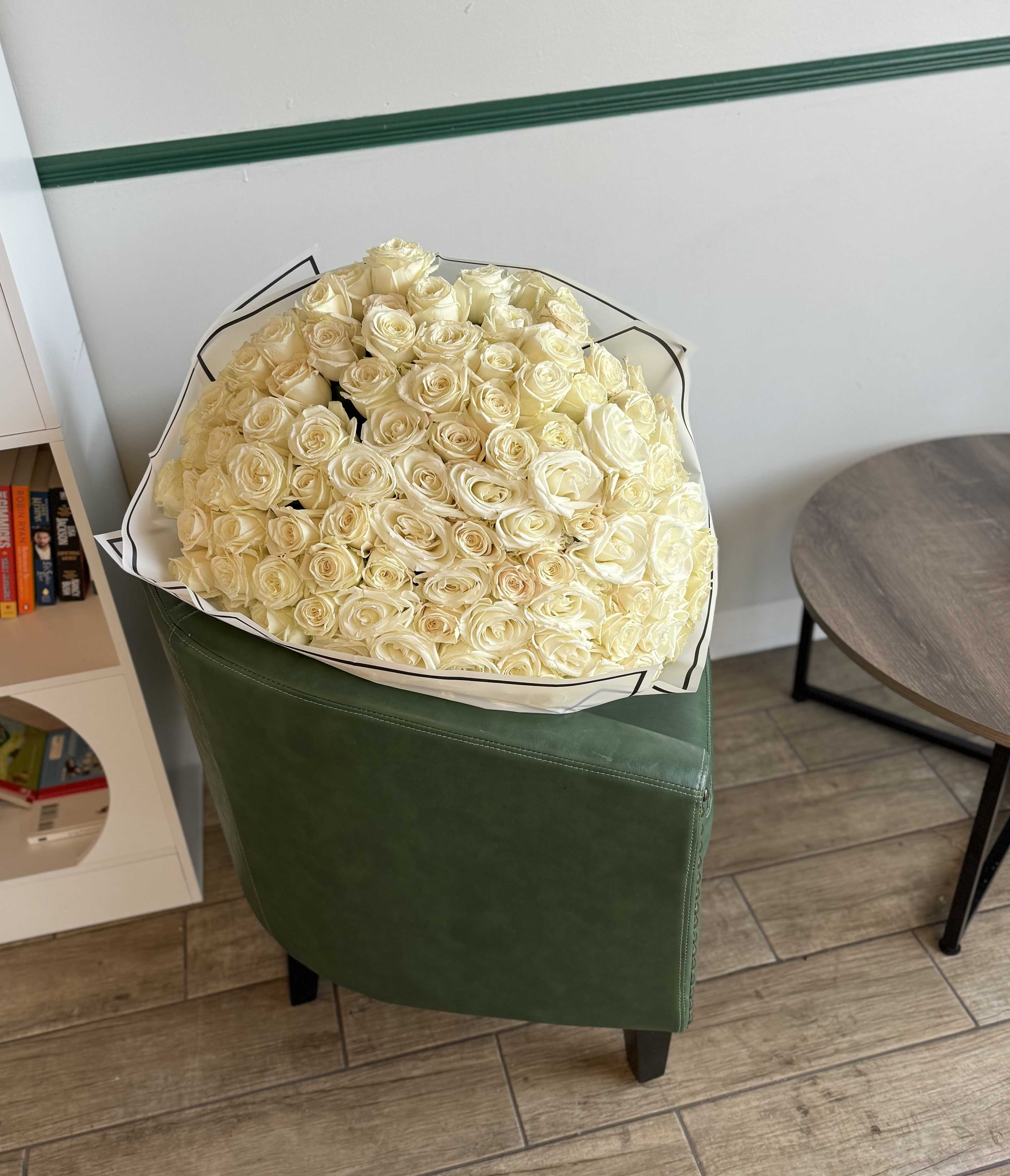 Large bouquet of cream roses wrapped in white paper