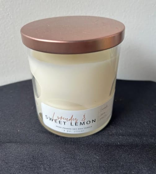 White soy wax candle in a glass jar with a copper lid labeled lavender and sweet lemon