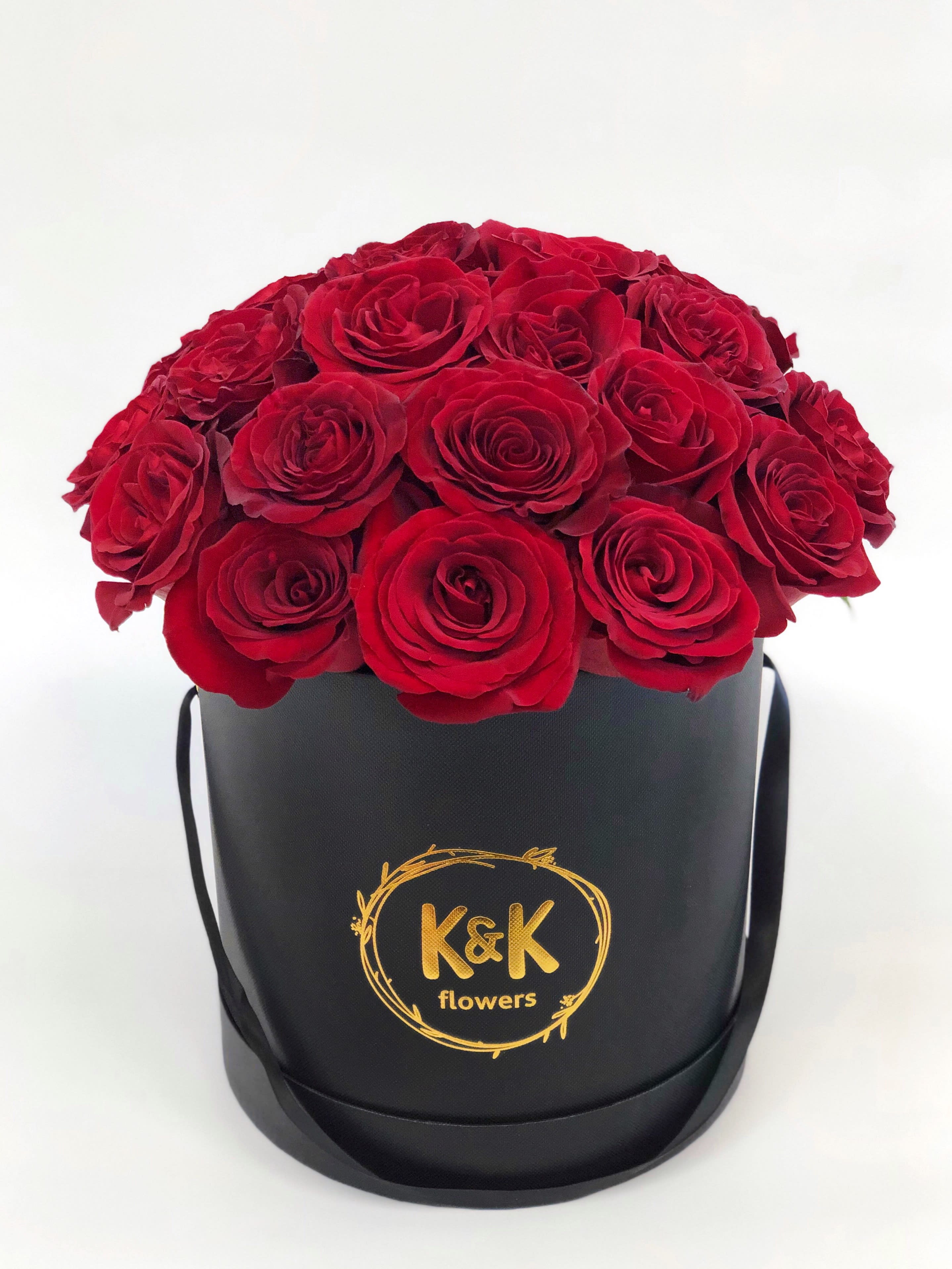 Red roses arranged in a black round hat box