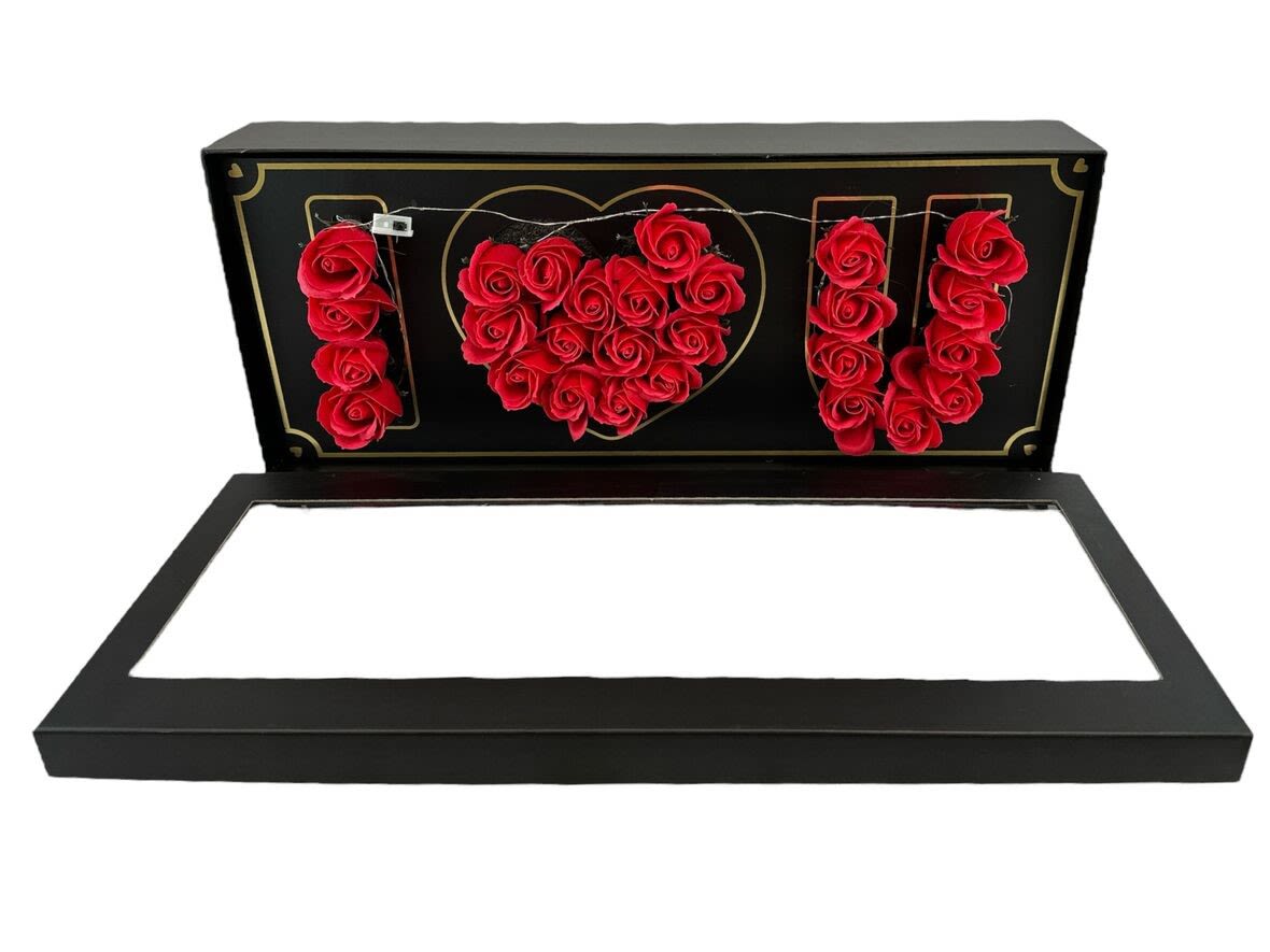 Black gift box with red roses arranged to spell I heart U inside the lid