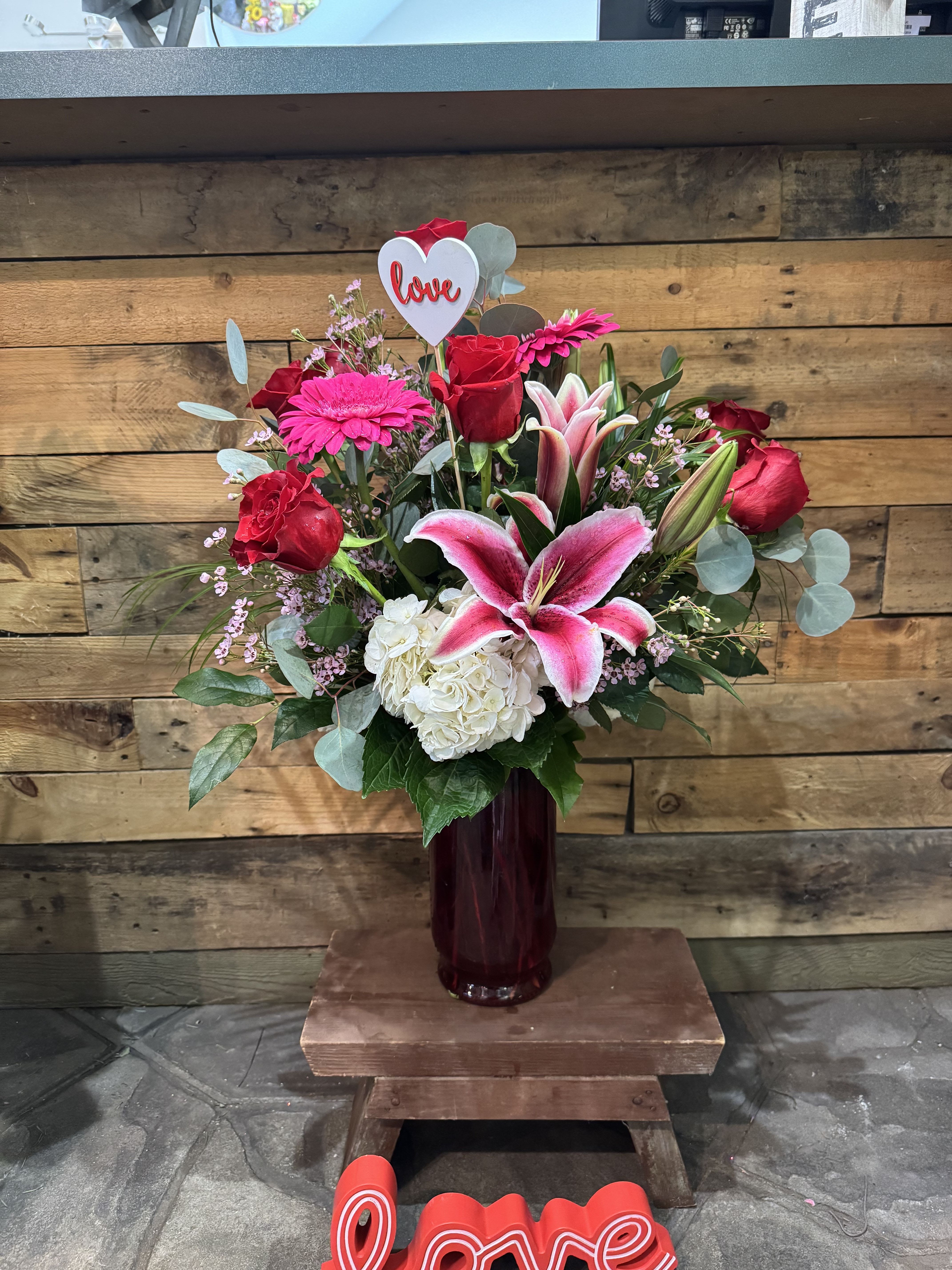 Bouquet of red roses, pink lilies, and white hydrangea in a vase