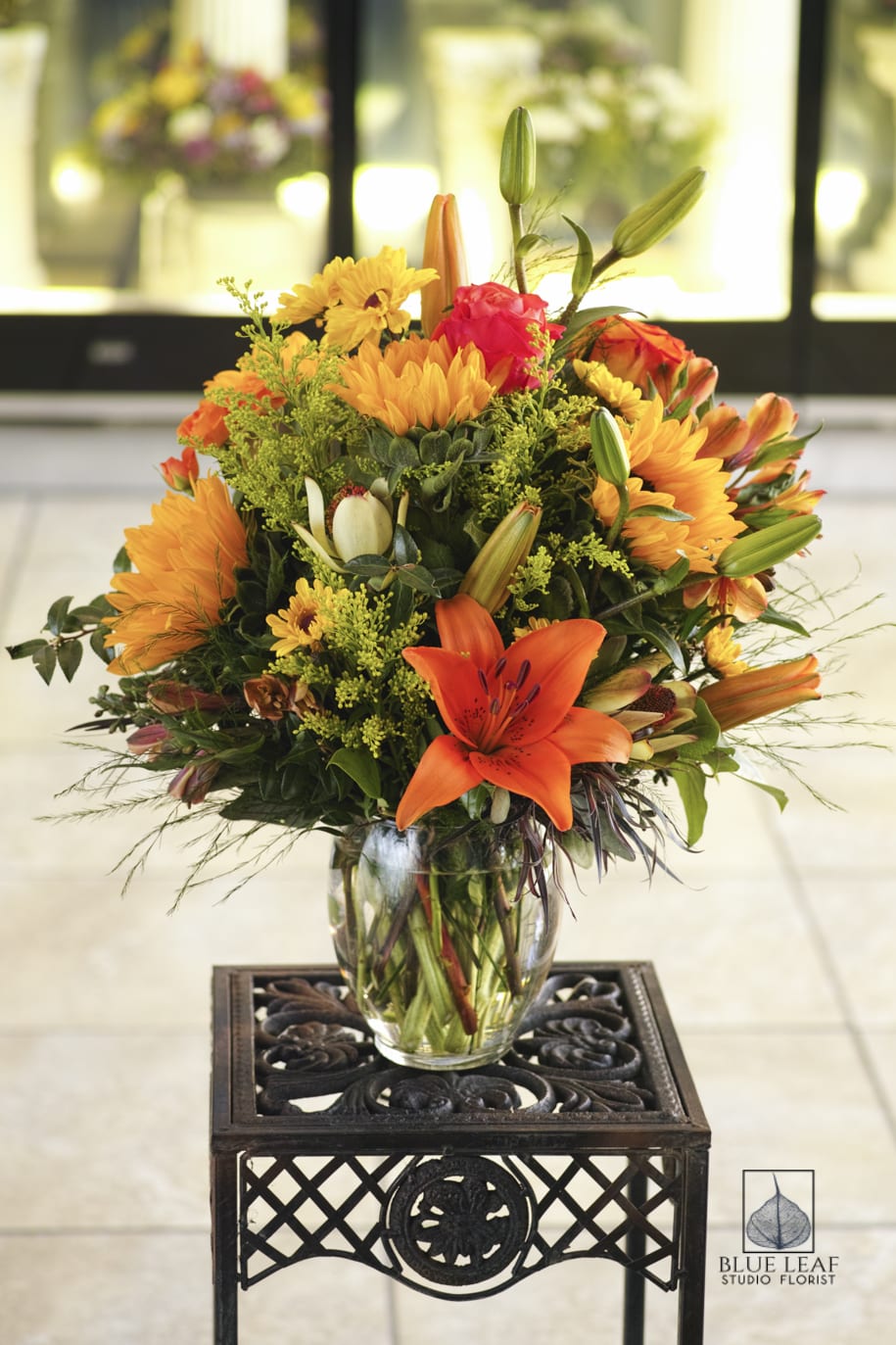 Orange and yellow mixed bouquet in a clear glass vase