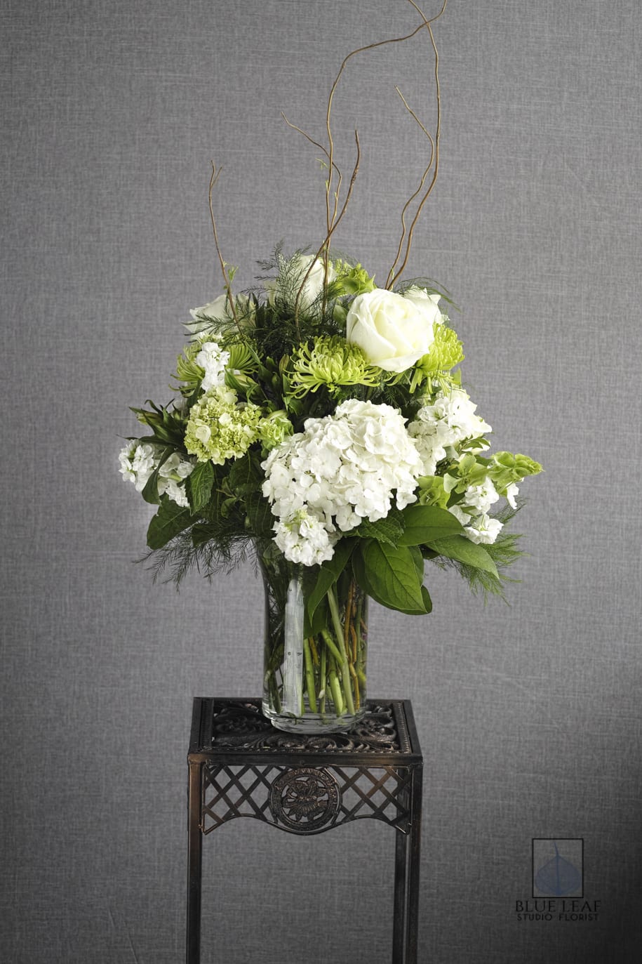 White and green floral arrangement in a clear glass vase