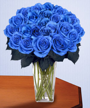 Blue roses arranged in a clear glass vase