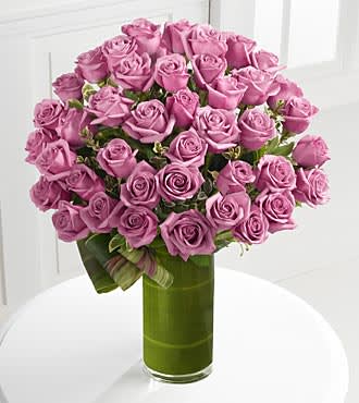 Bouquet of pink roses in a tall green glass vase