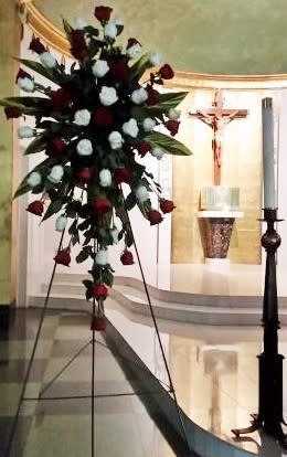 Tall floral spray with red and white roses on a stand