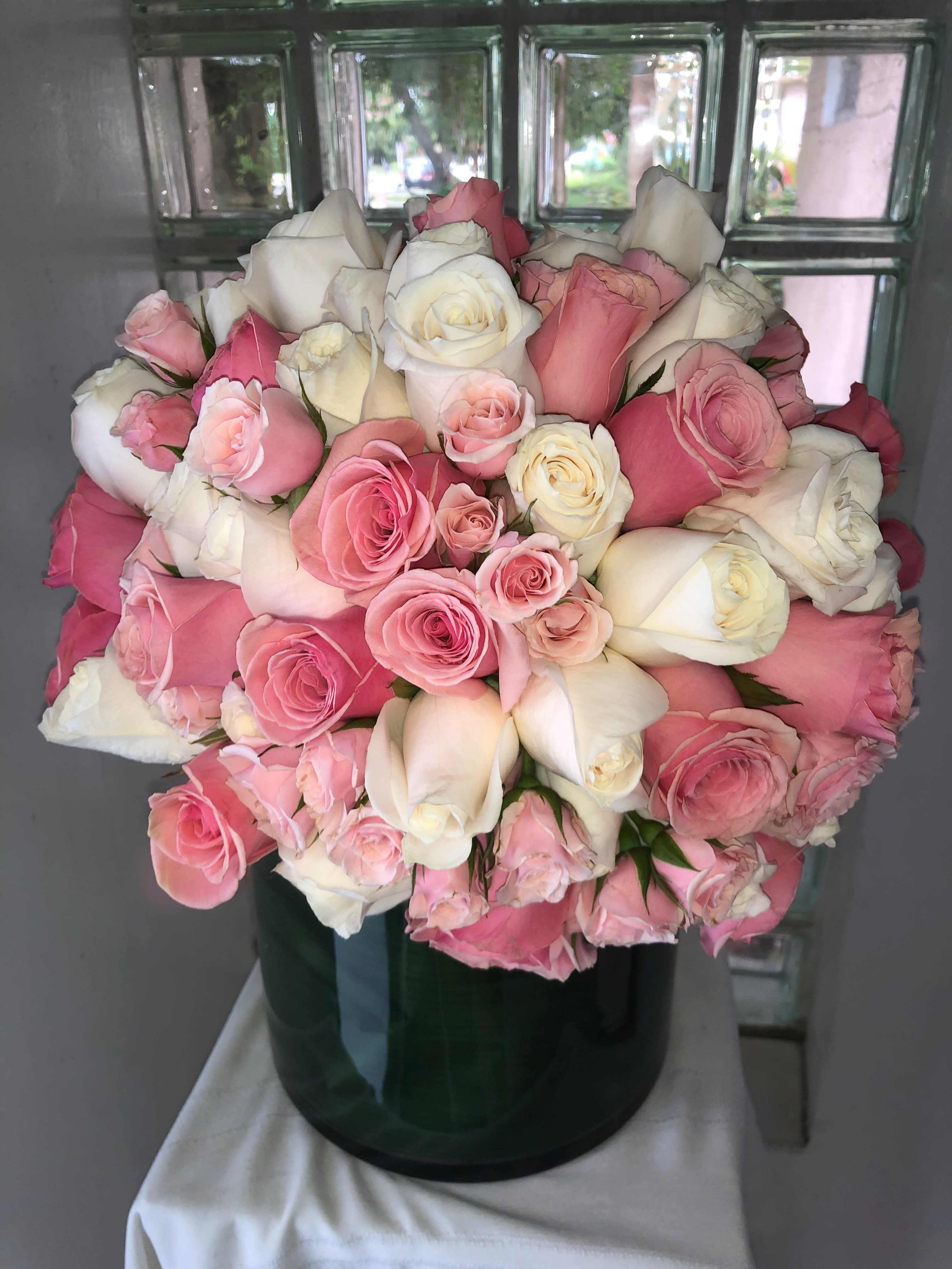 Bouquet of pink and white roses in a dark glass vase