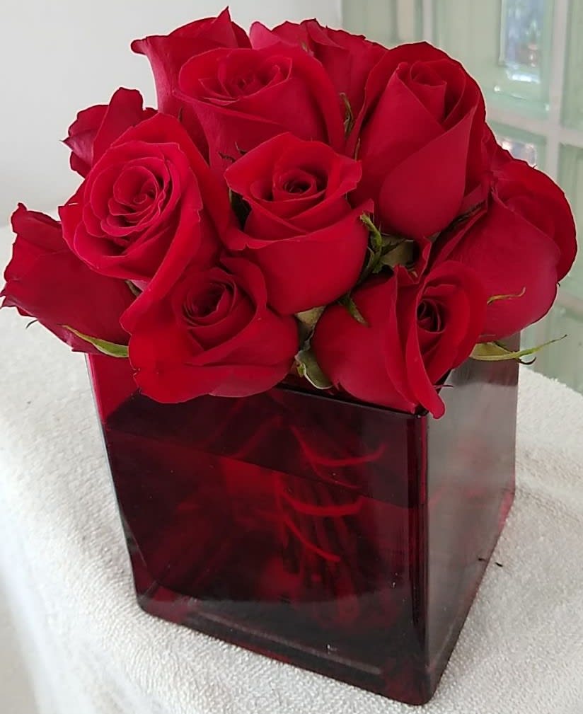 Red roses arranged in a square glass vase