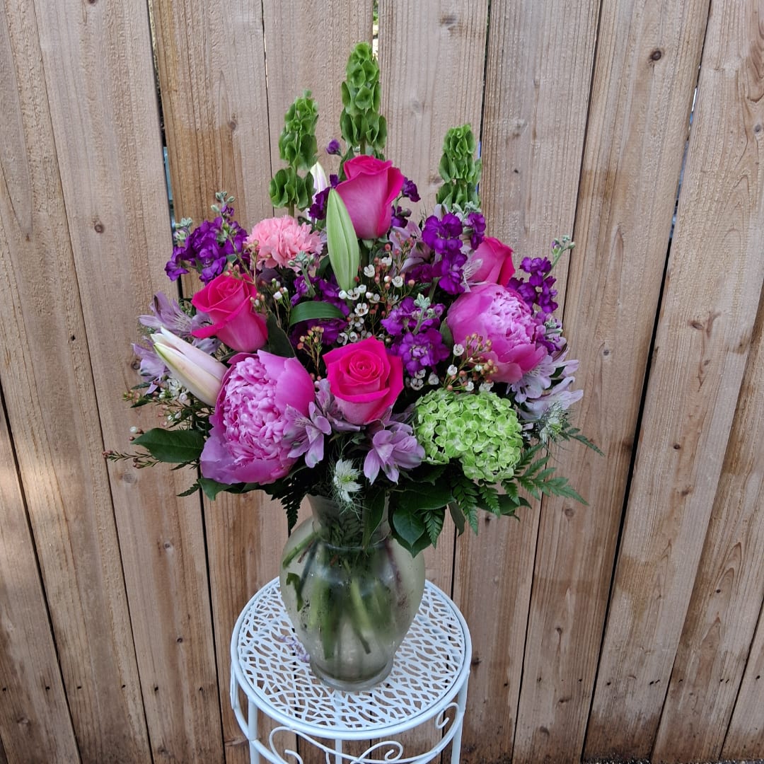 Pink and purple mixed flower arrangement in a glass vase
