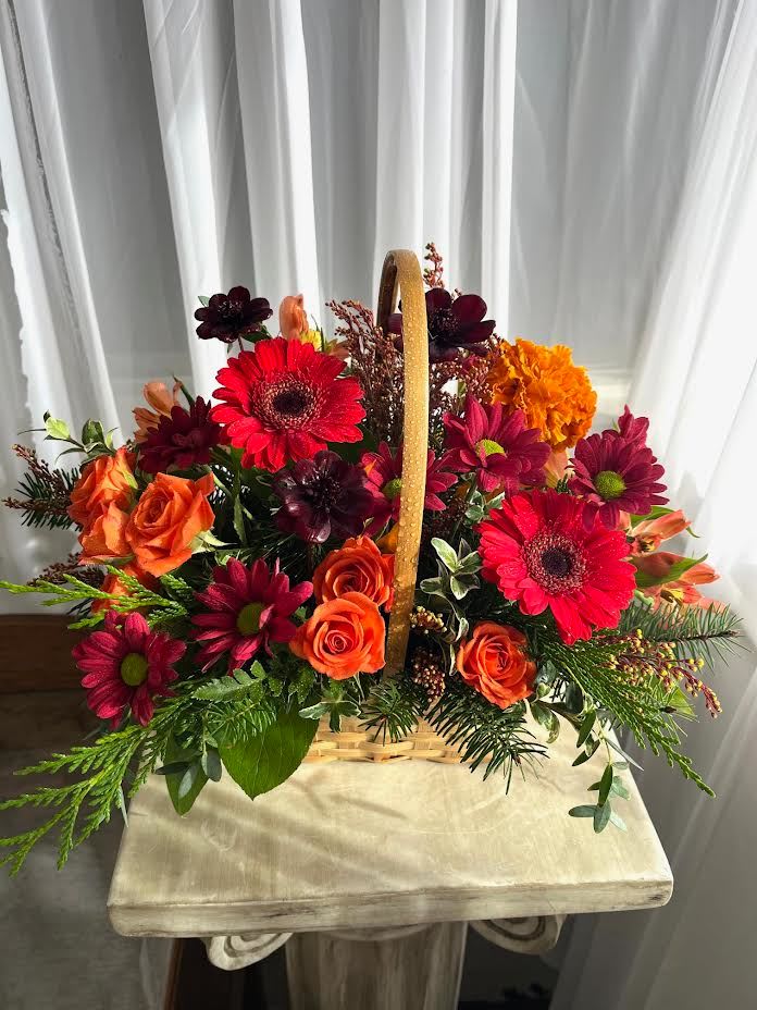 Eager for Autumn - A basket filled with such fall beauties; such as orange spray roses, red mini gerbs, chrysantheums, and more.  As always, call the shop to find out what we have in stock, because our inventory constantly changes; and we often have to substitute flowers/colors based on what's available.