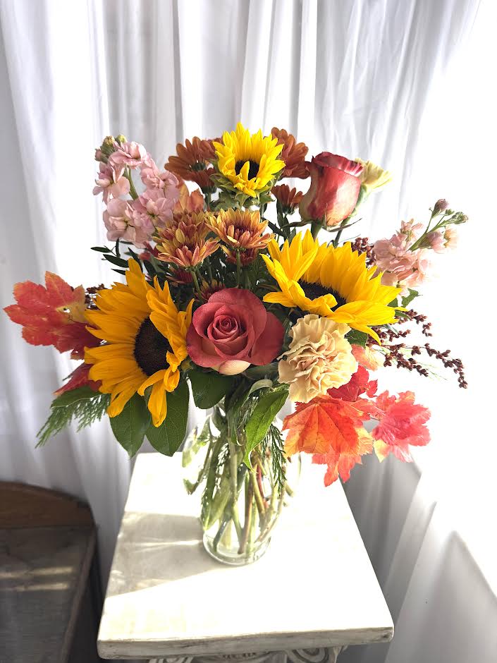 Fall Leaves on the Breeze - A gathering of autumn favorites!  Sunflowers, roses, stock, and more.  Our inventory constantly changes; so we reserve the right to substitute as necessary.  Call shop to find out what exactly we'll be using.