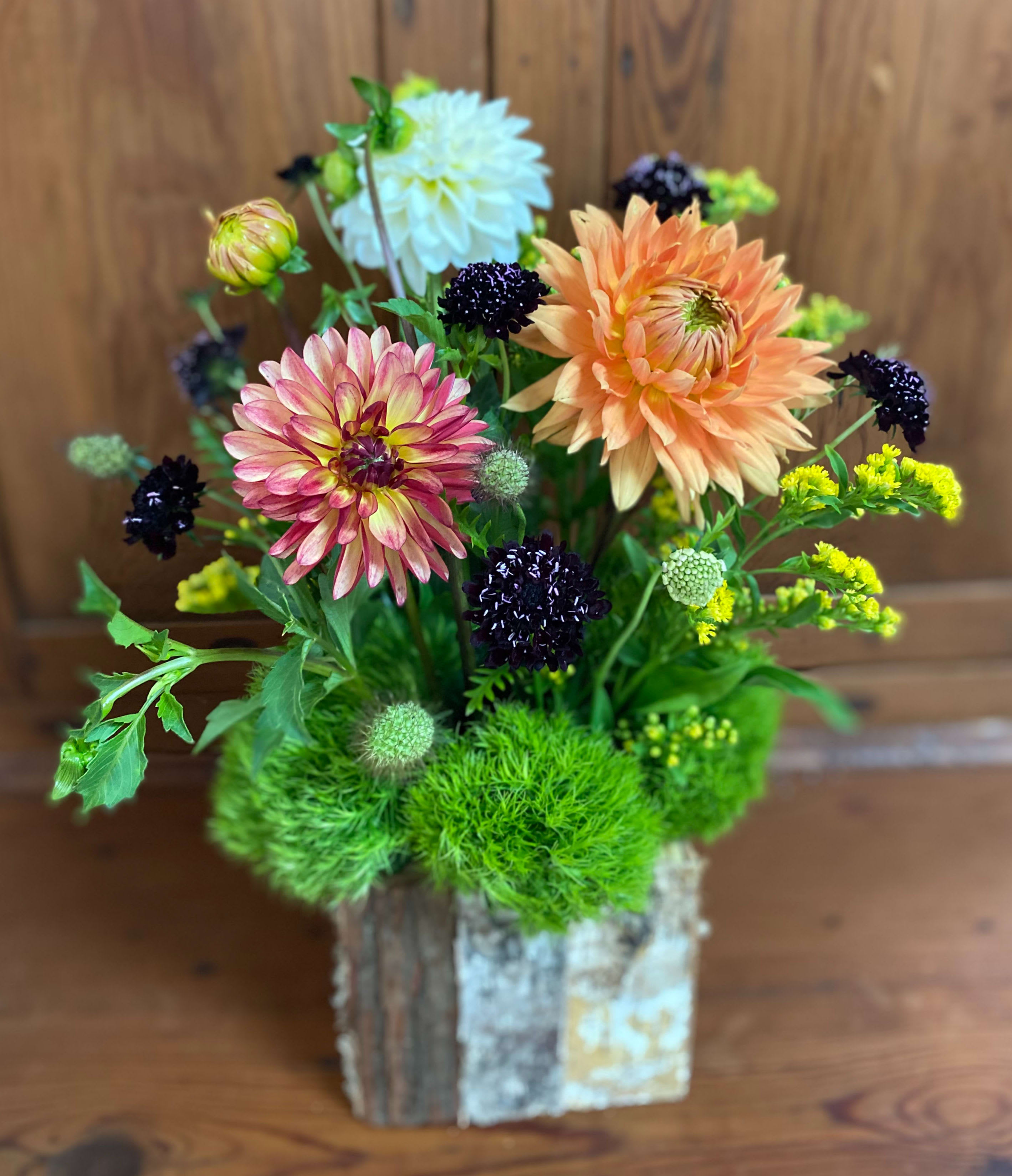 Mixed dahlia arrangement in a rustic wooden container